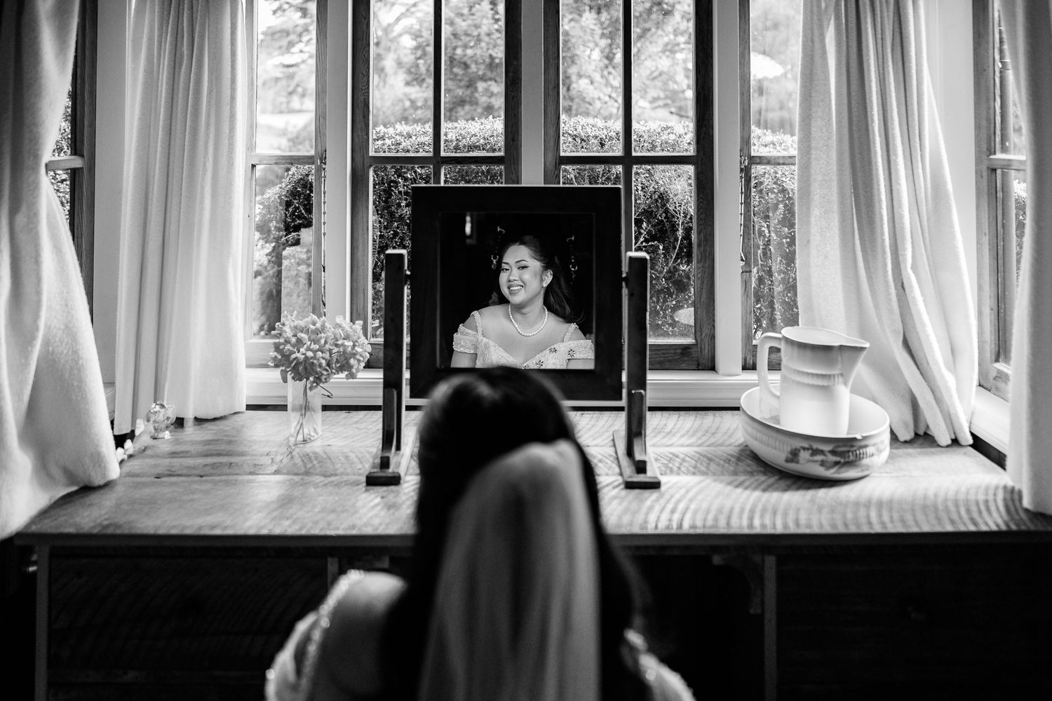 Black and white photo series showing a bridal gown through window-lit interior scenes.