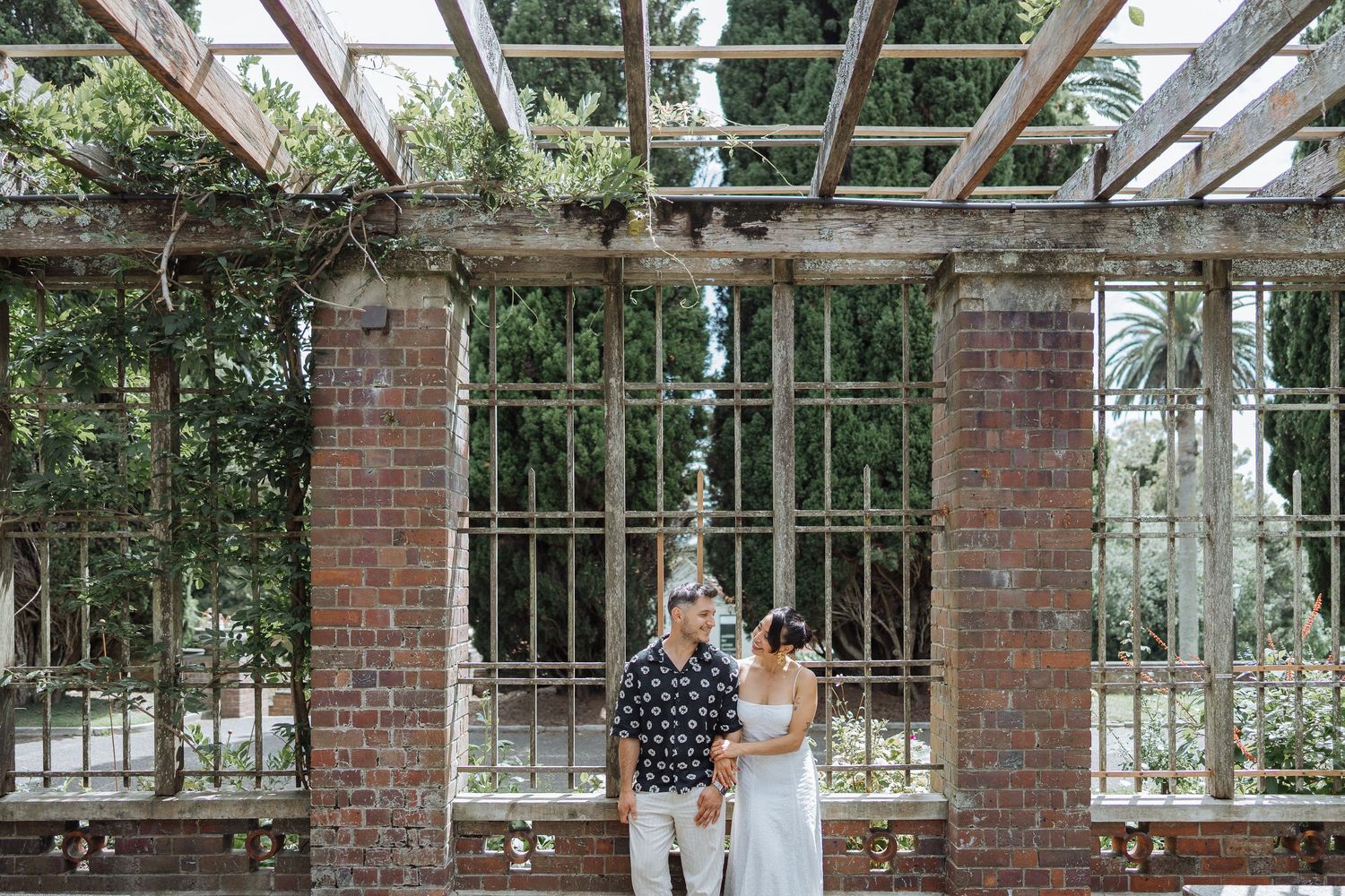 A greenhouse or conservatory with brick pillars and glass panels creates an elegant architectural space.