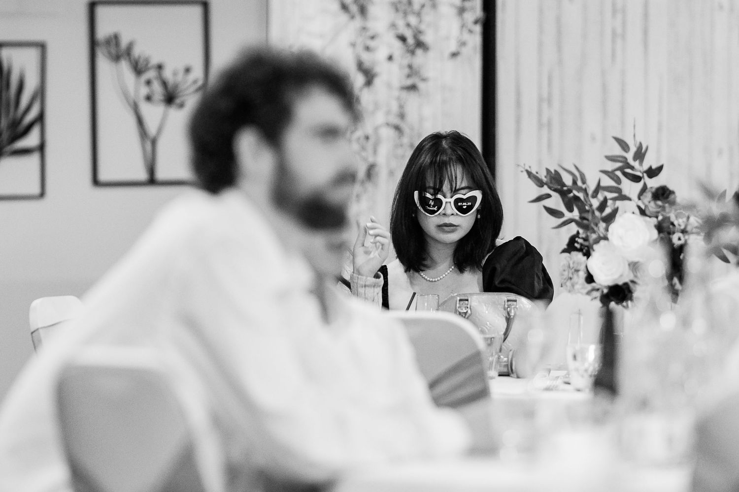 Black and white photo of wedding reception guests enjoying the celebration.