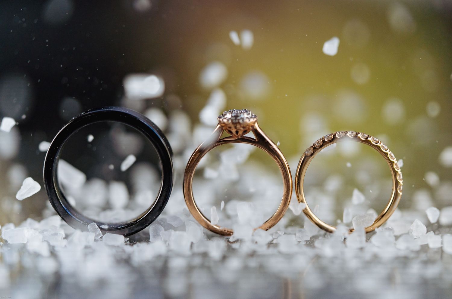 Wedding rings arranged in an artistic macro shot with bokeh lighting effects.