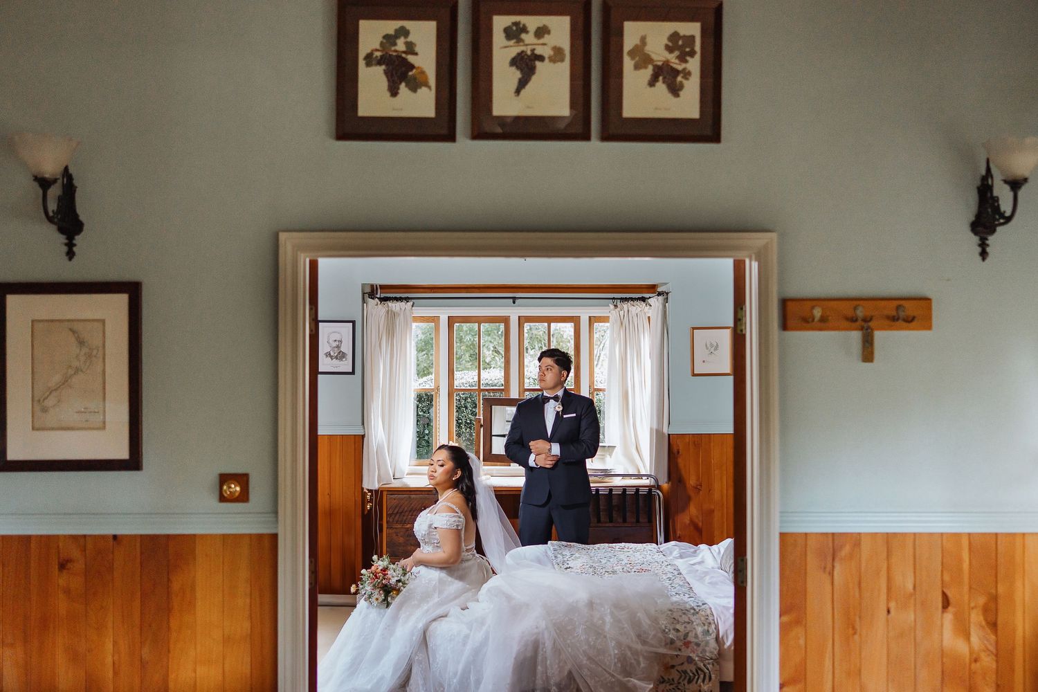 Interior hallway with wooden panels and framed artwork in wedding venue.