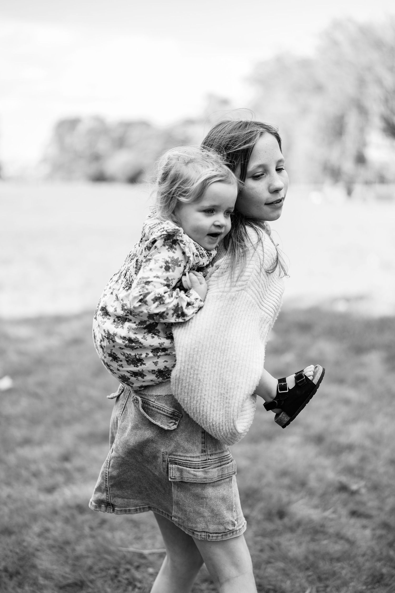 Black and white images of joyful moments between family members in a field.