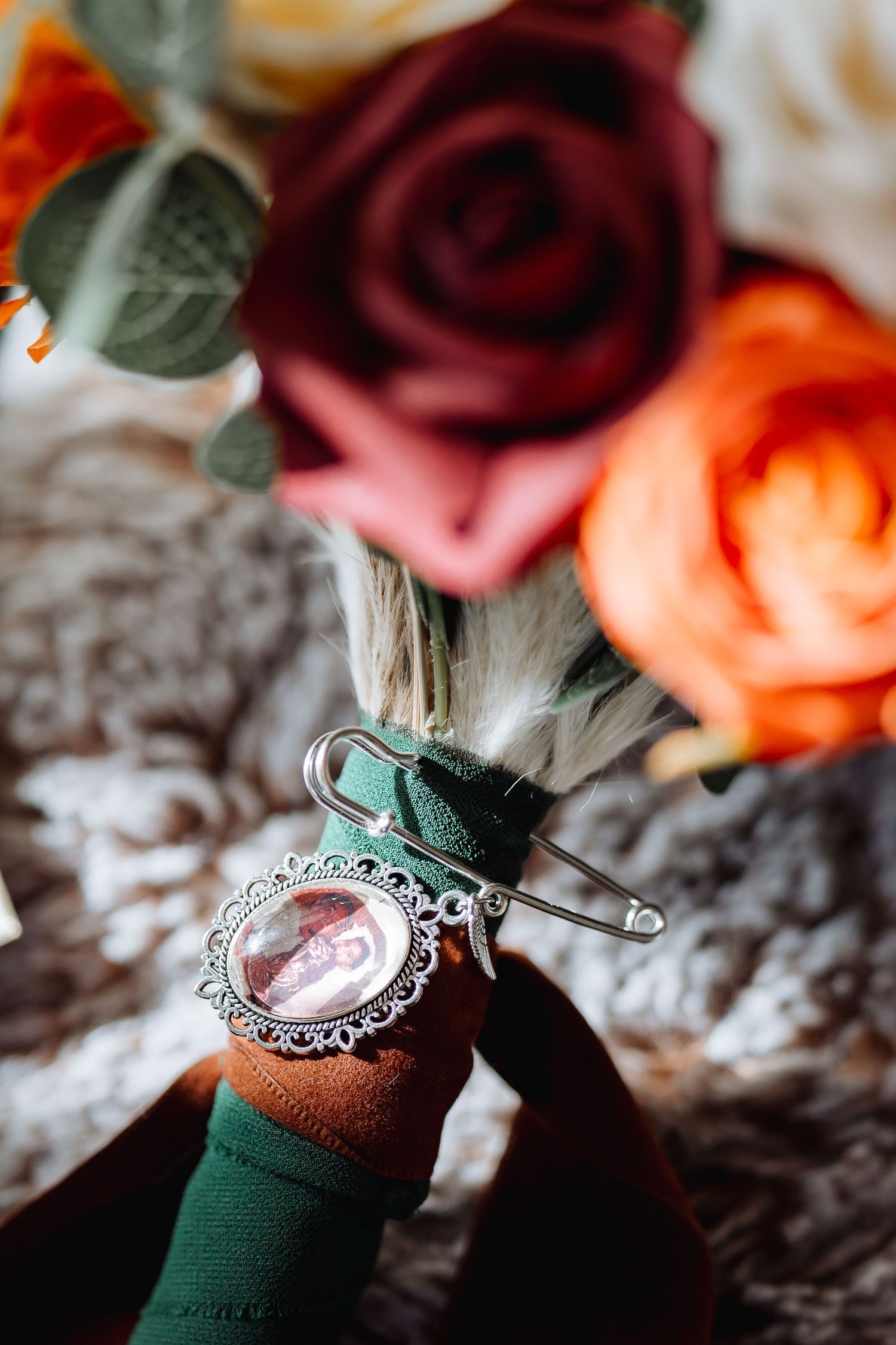 Close-up of vintage-style brooch with roses and floral arrangements.