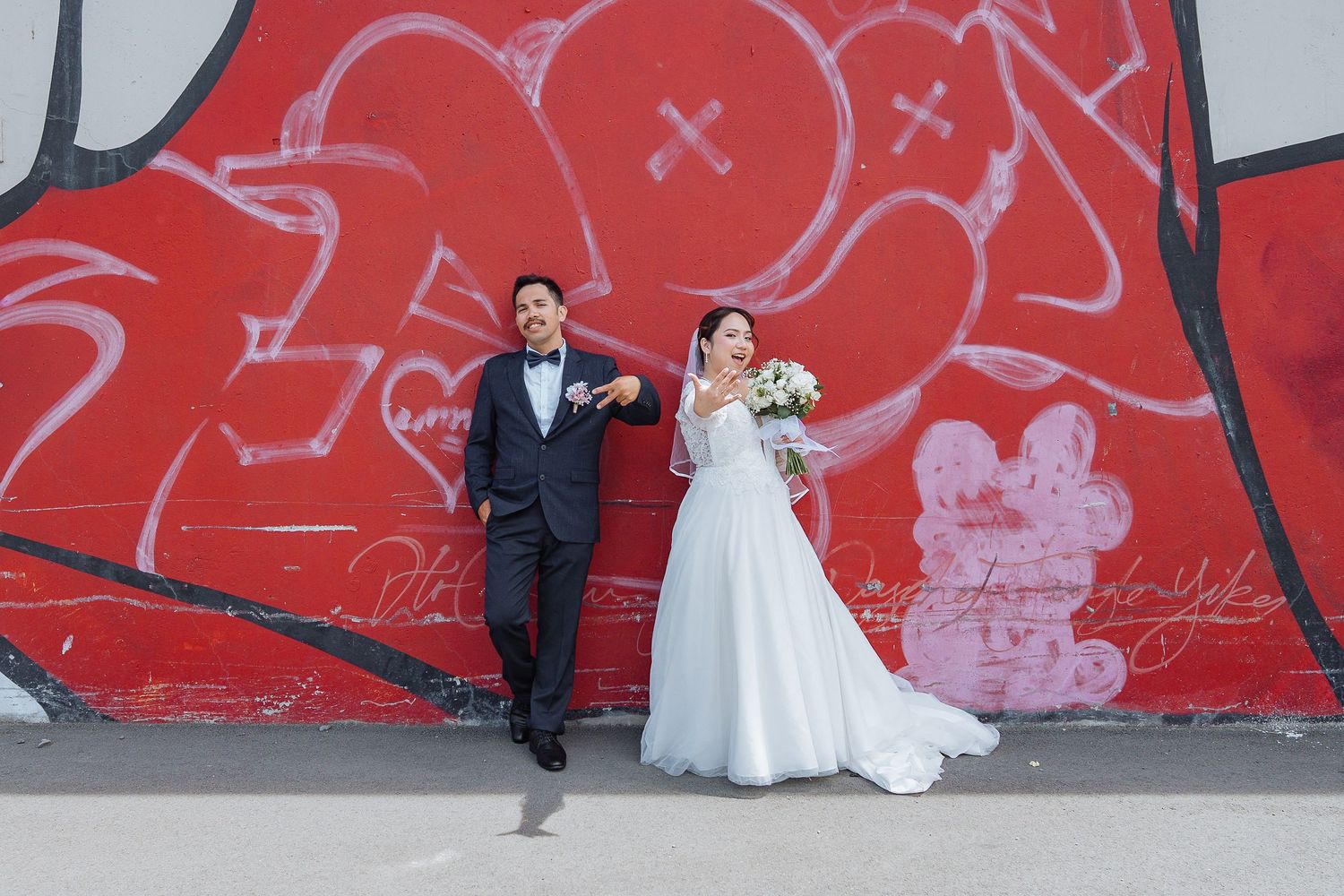 Wedding photo series against vibrant red wall with graffiti art.