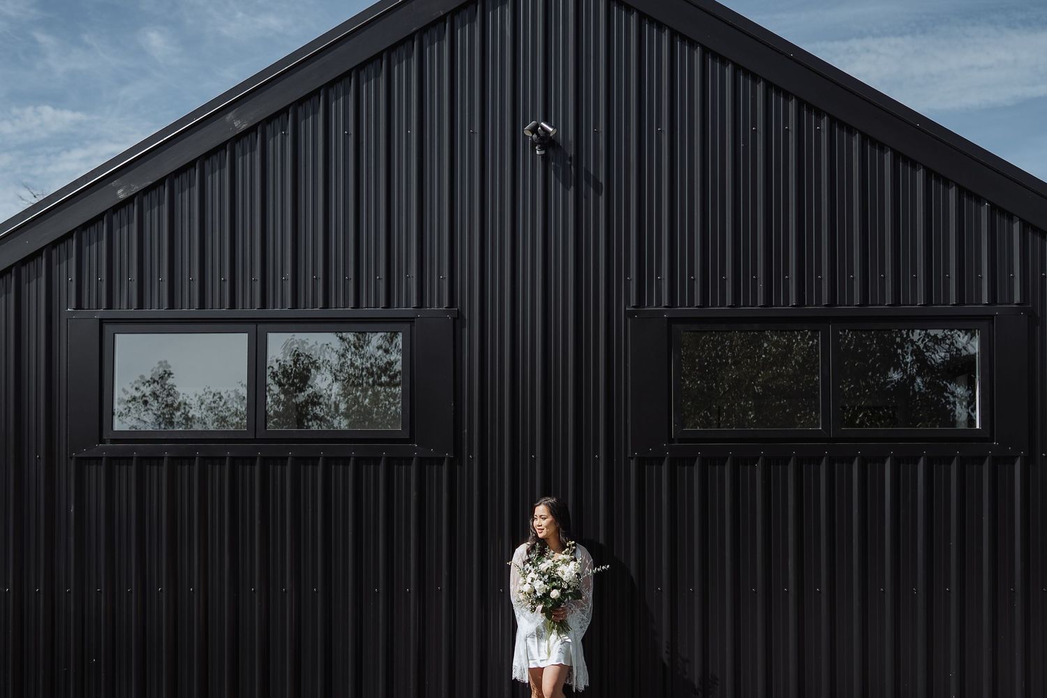 Modern black barn-style building exterior with minimalist design.
