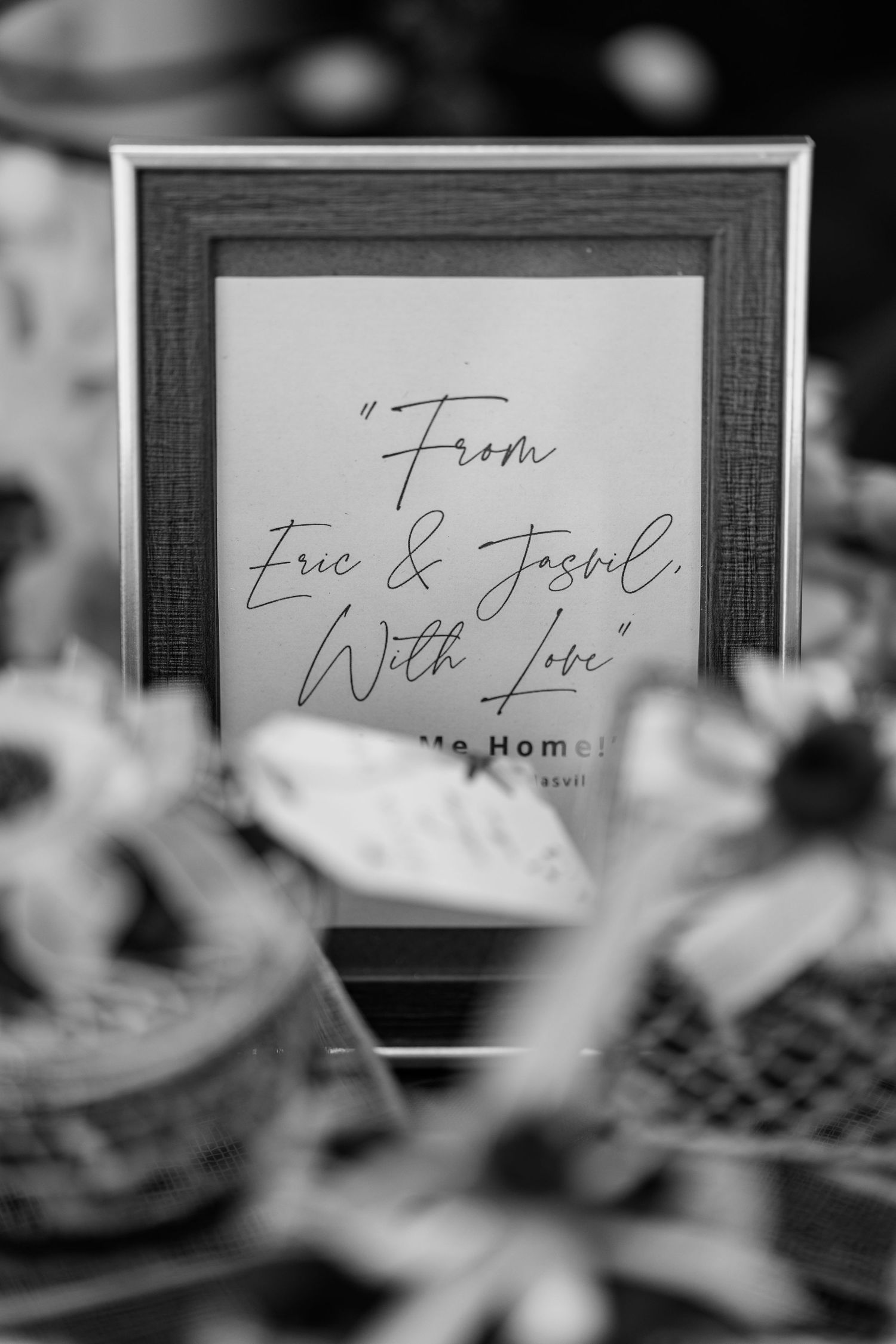 Black and white detail shot of handwritten wedding place cards on a table.