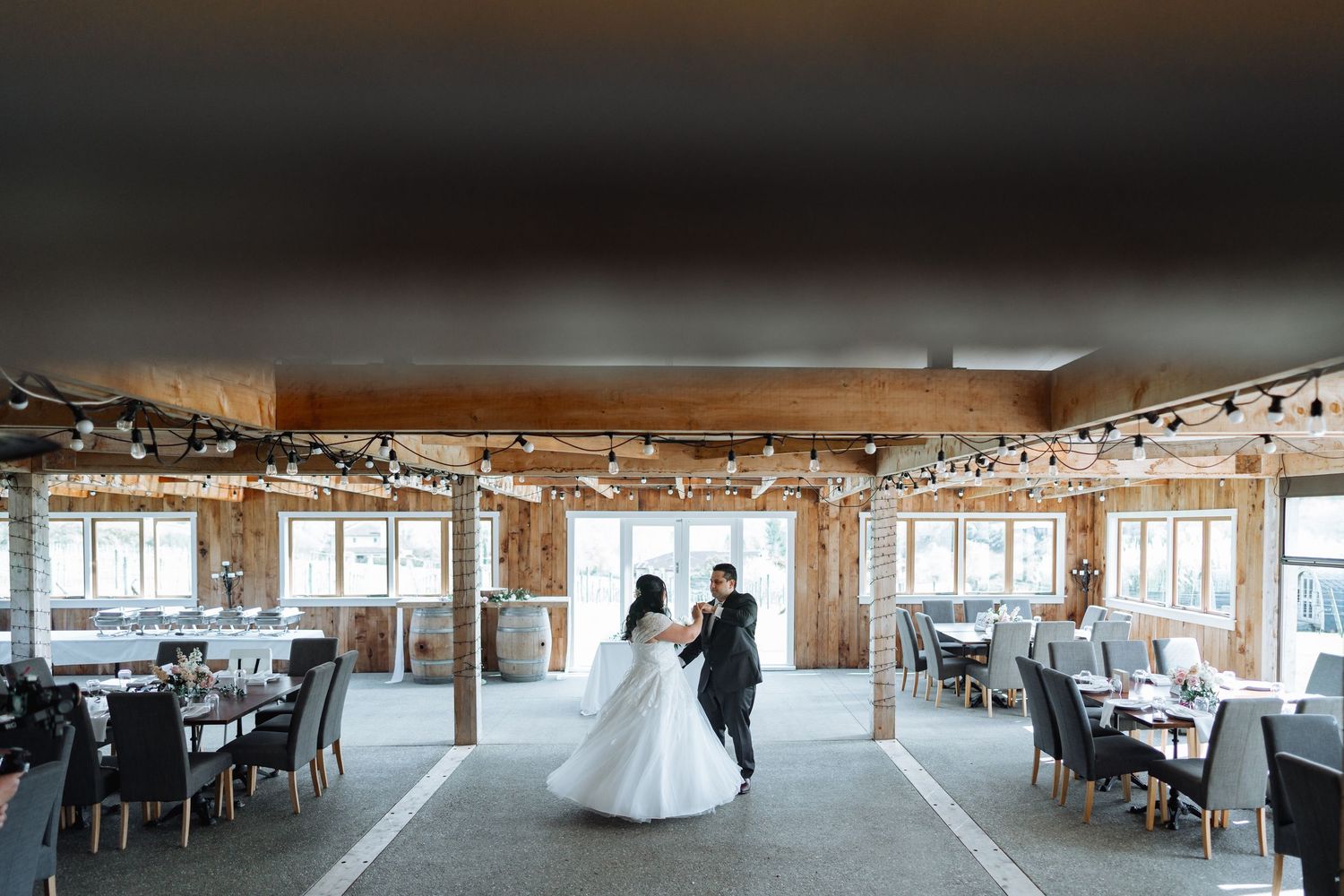 Spacious wedding reception venue with panoramic windows and elegant table settings.