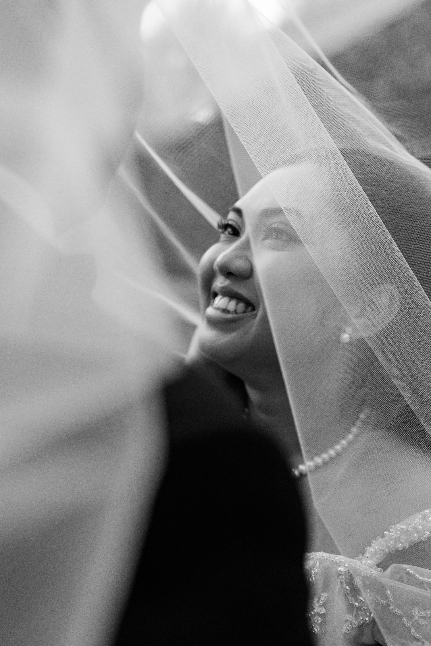 Close-up black and white detail of delicate bridal veil with soft focus.