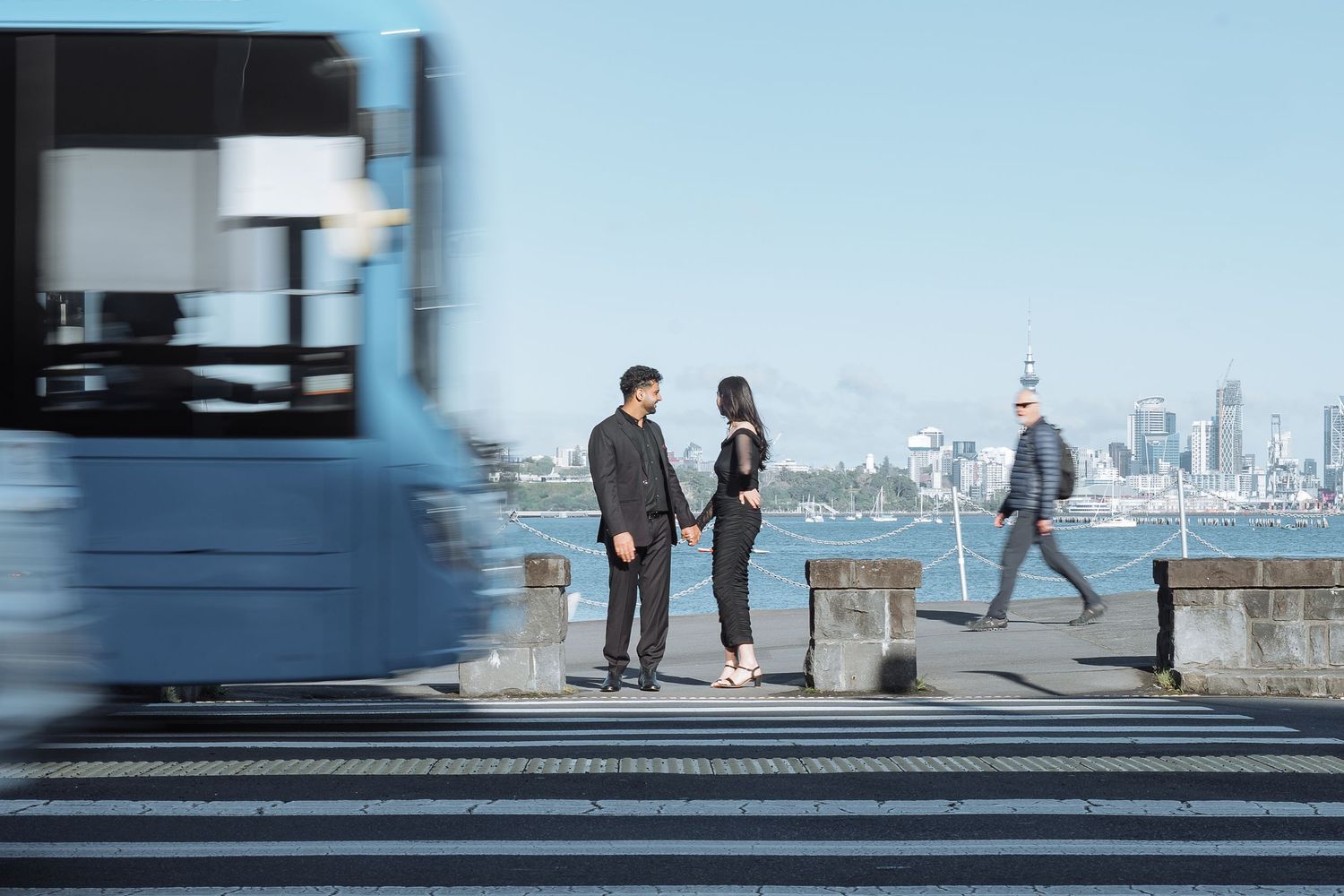 People photographed against a bright blue sky on an urban pier.