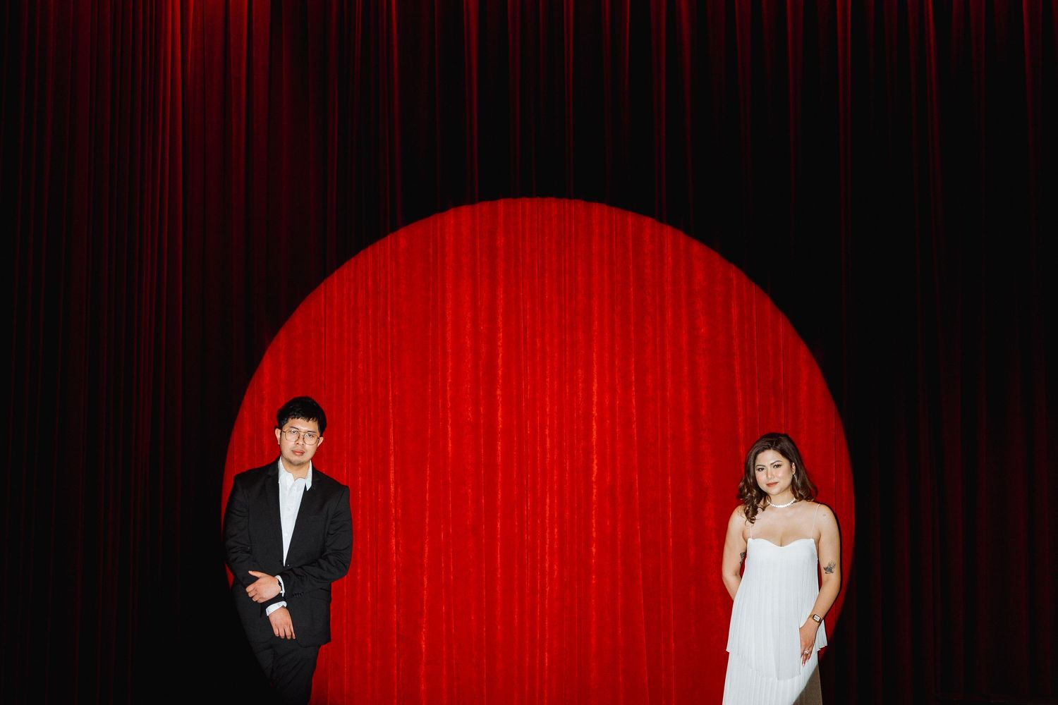 Romantic photo series against a dramatic red curtain backdrop in a theater setting.