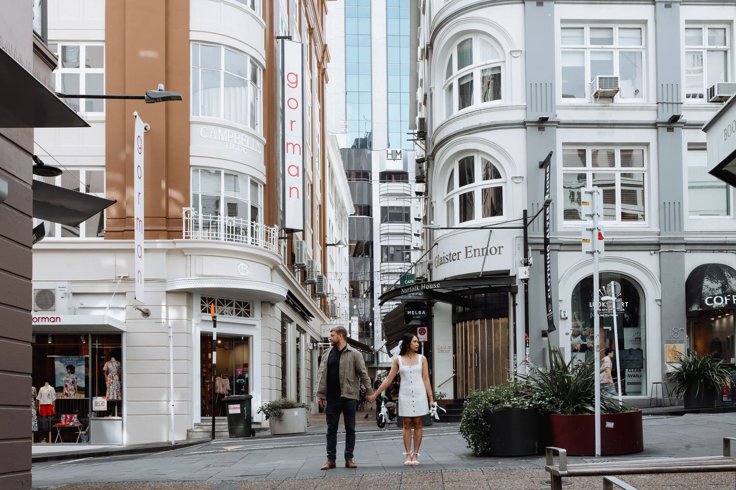 Row of Victorian style buildings with white and brown facades along a city street.