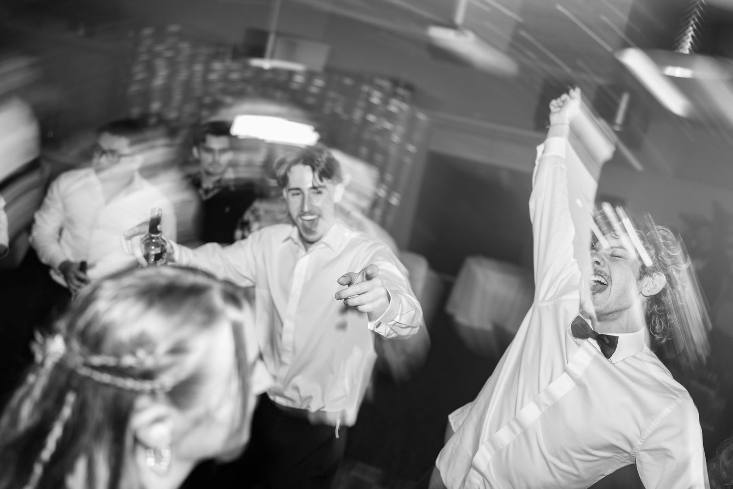 Dynamic black and white shots of wedding reception dancing and celebrations.