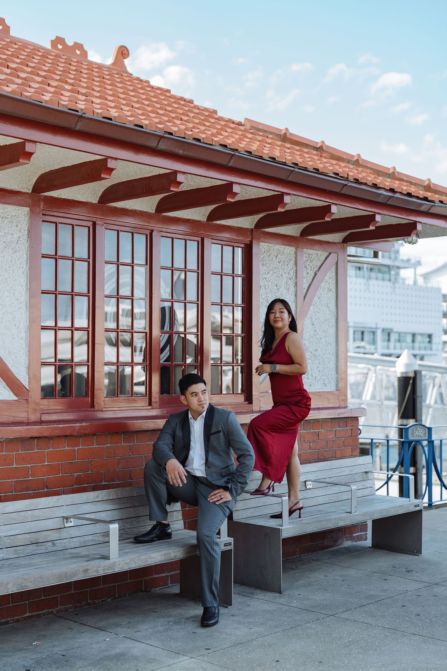Red-roofed building with wooden beams and windows overlooking city skyline.