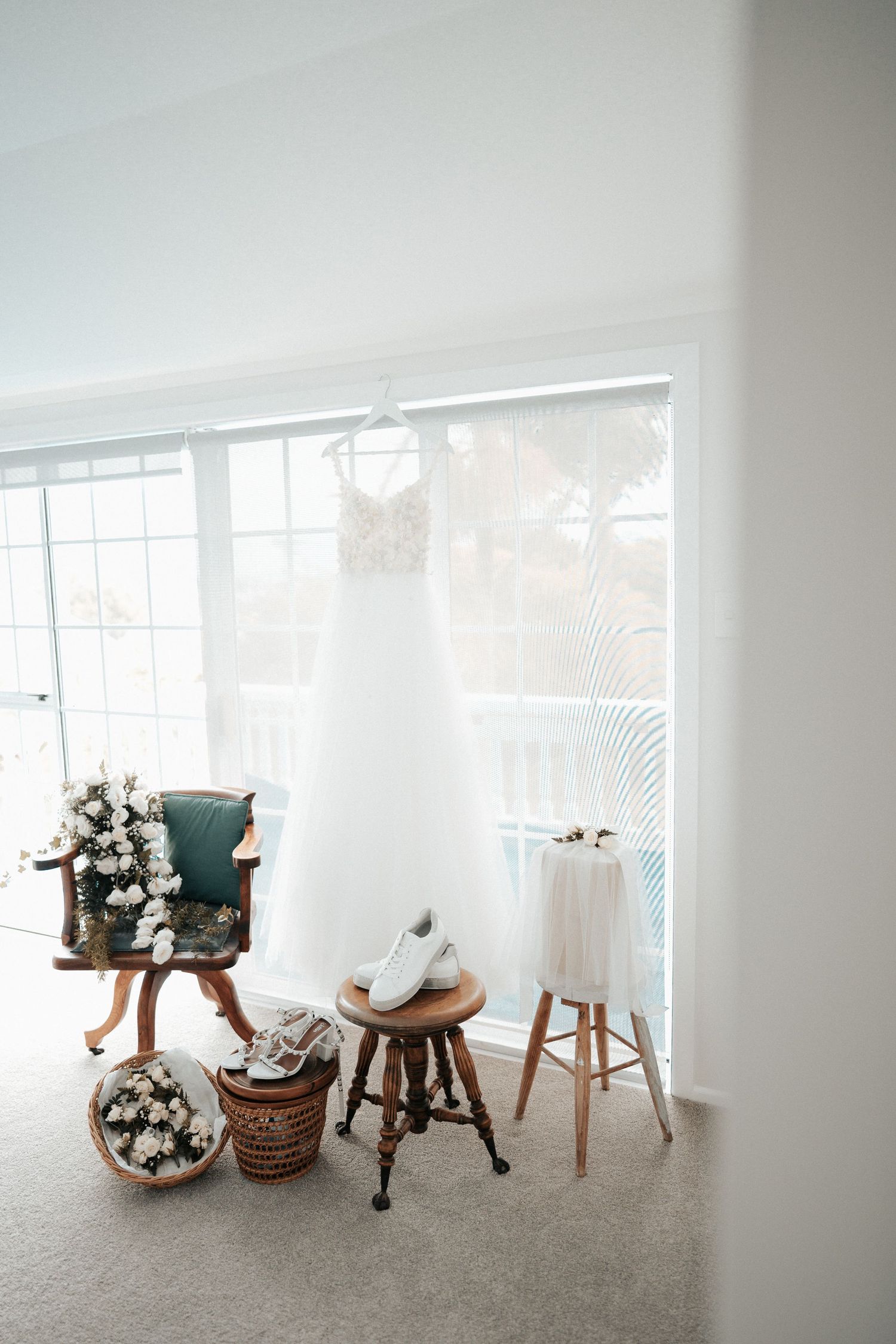 A minimalist white interior space with decorative items and furniture arranged near a window.