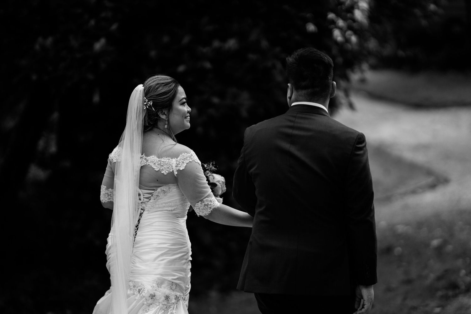 Black and white wedding portraits captured in elegant outdoor setting.