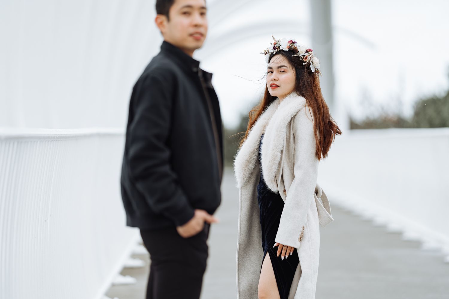 Couple in black and white outfits pose together outdoors during a romantic photoshoot.