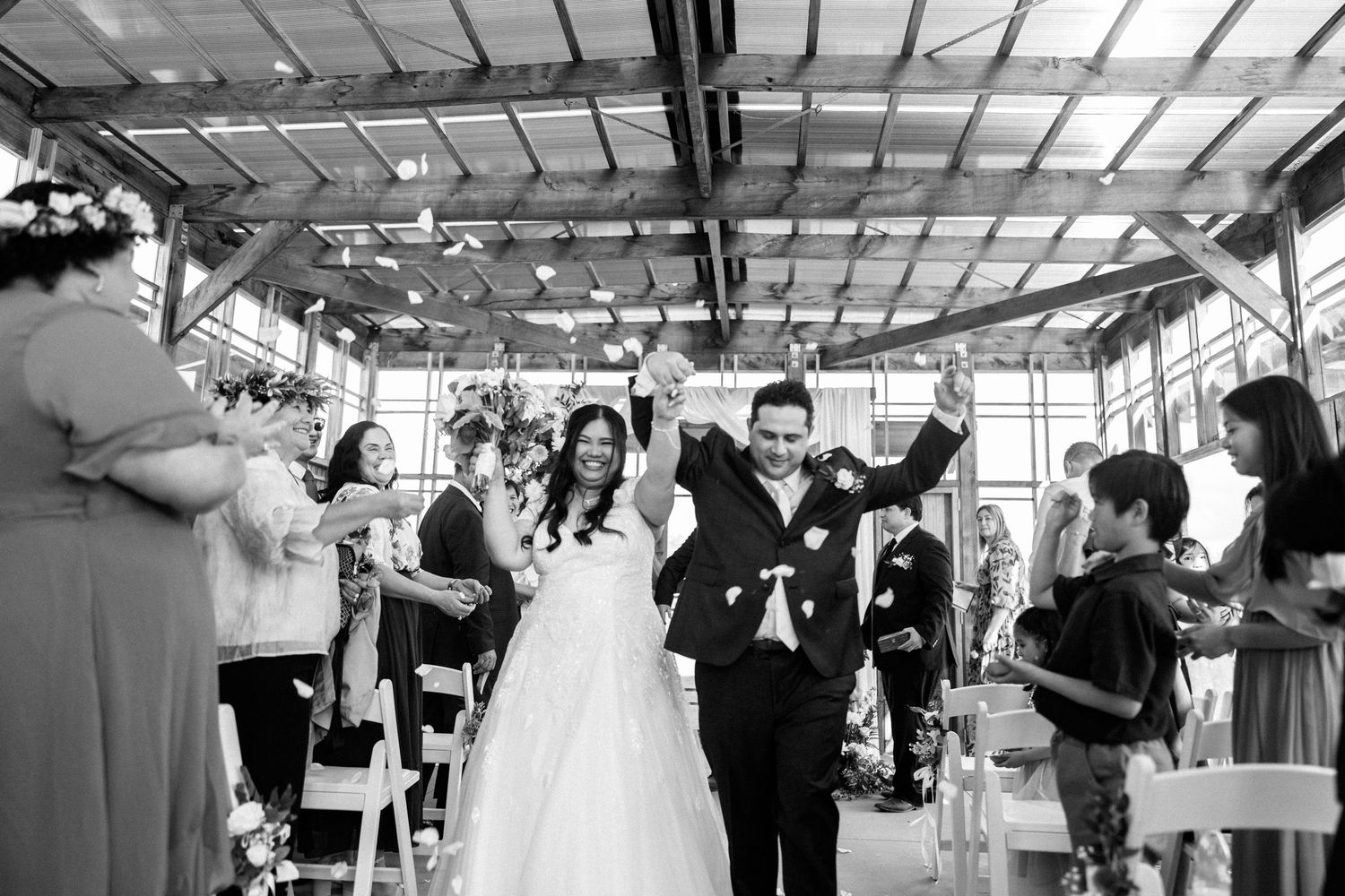 Wedding celebration in a bright indoor venue with guests dancing and mingling.