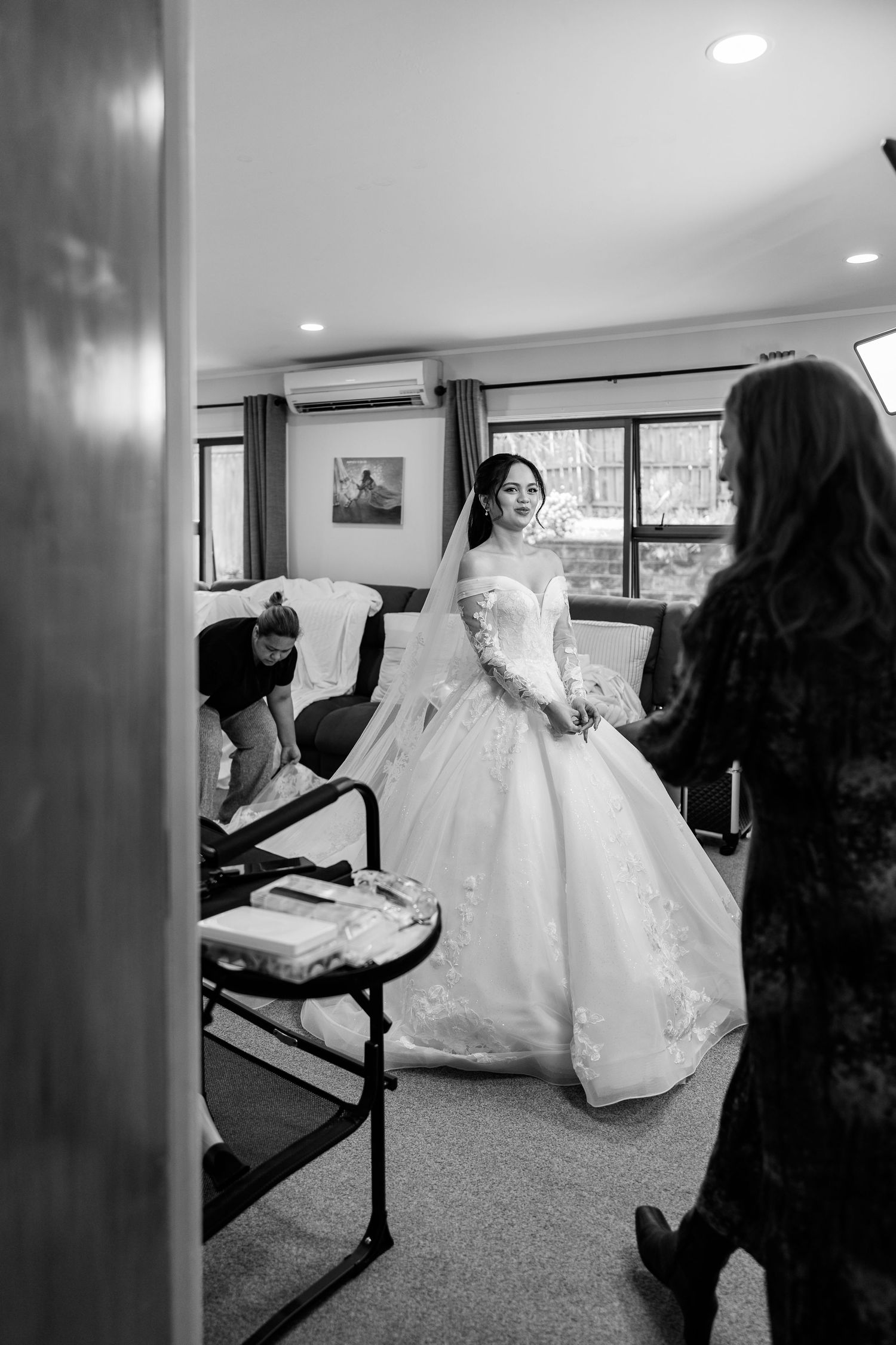 Wedding dress preparation in a bridal suite with natural lighting.
