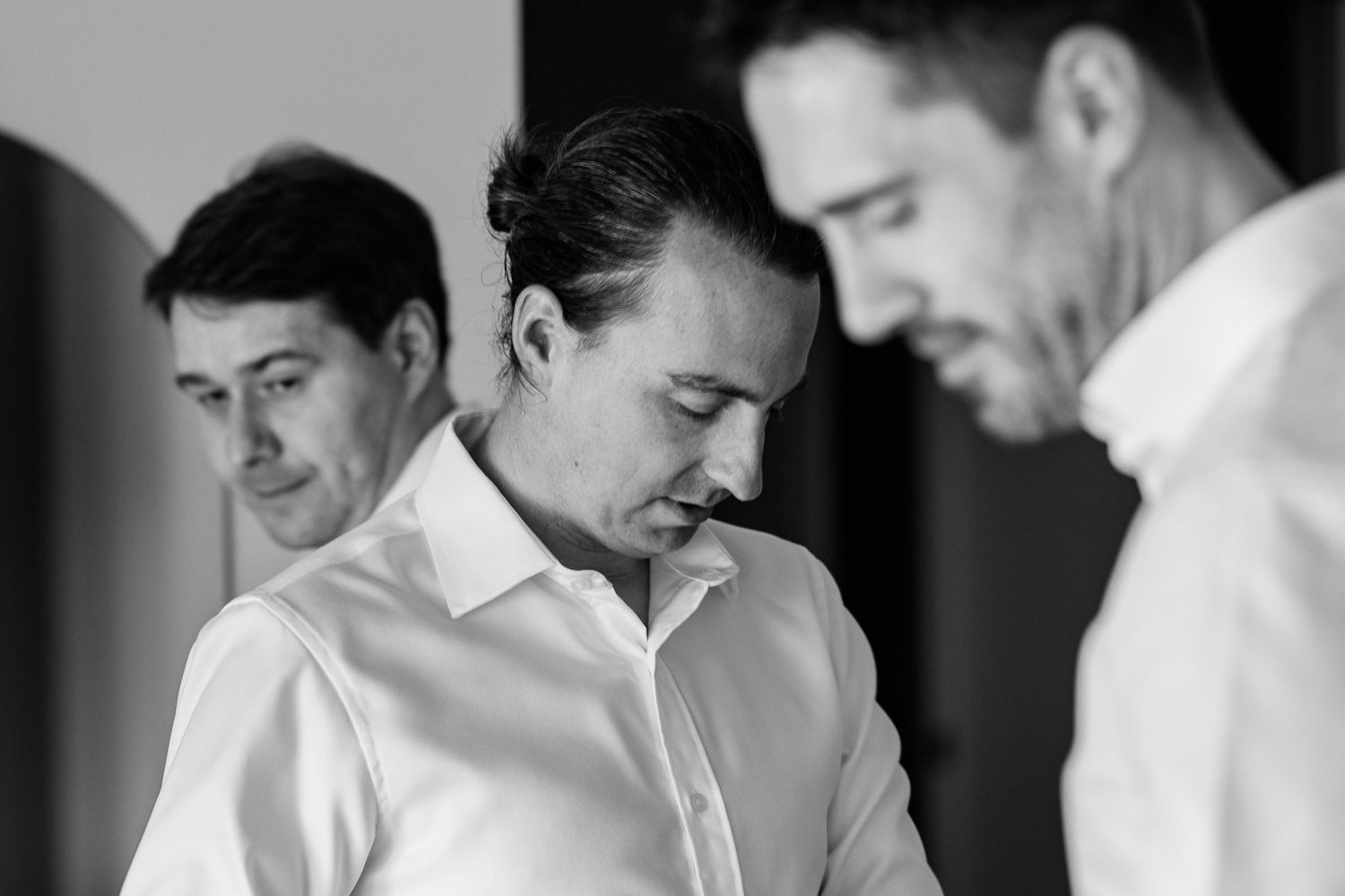 A group of people in white and black attire preparing for a formal event.