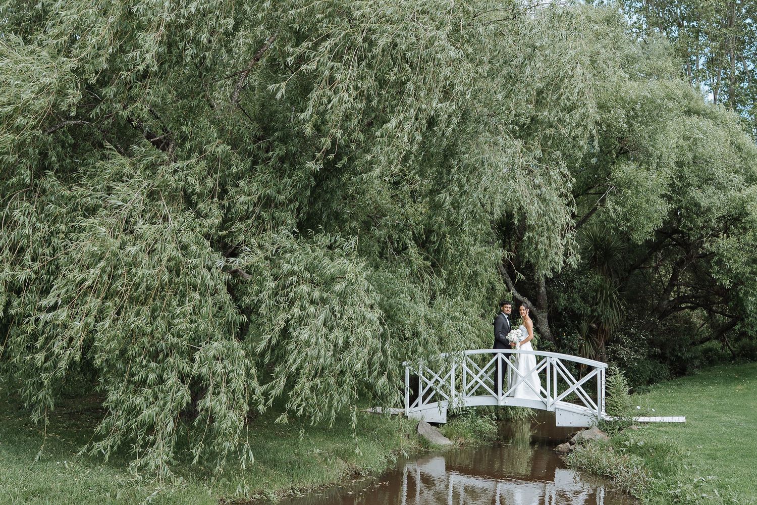 White gazebo and garden setting prepared for outdoor wedding ceremony.