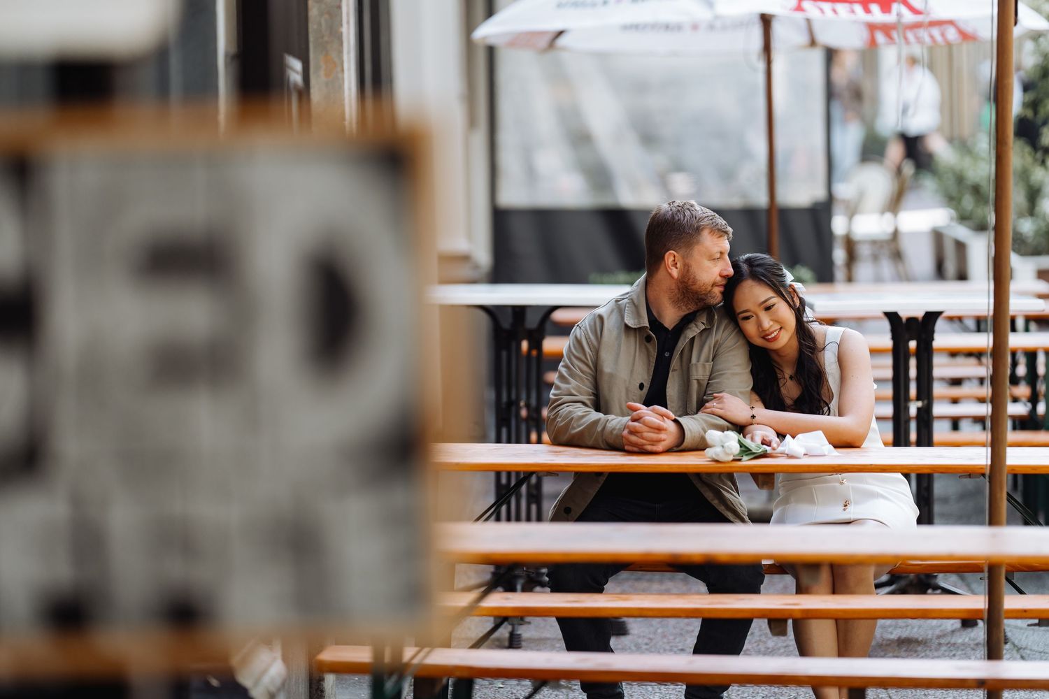 A couple shares tender moments across multiple frames at an outdoor cafe.