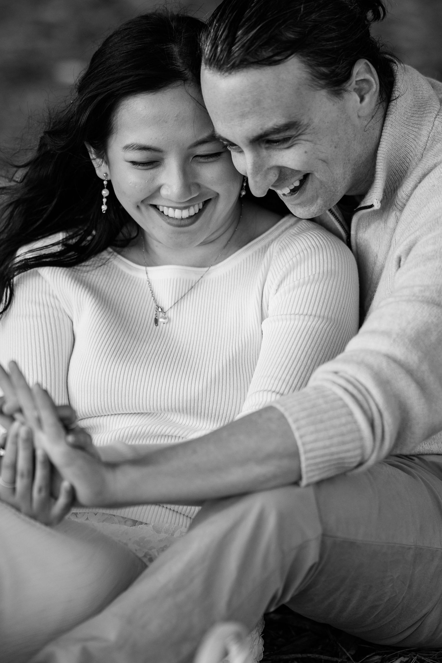 An intimate black and white portrait capturing genuine laughter and connection.