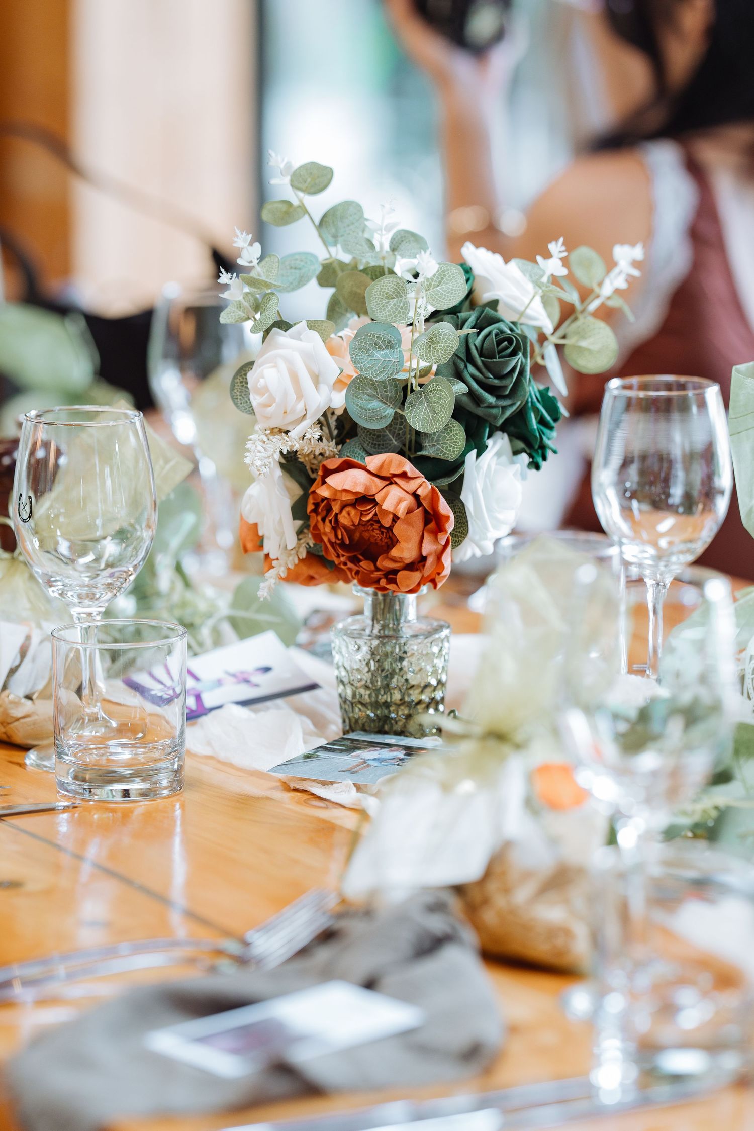 Elegant wedding reception table setting with peach flowers and eucalyptus centerpieces.