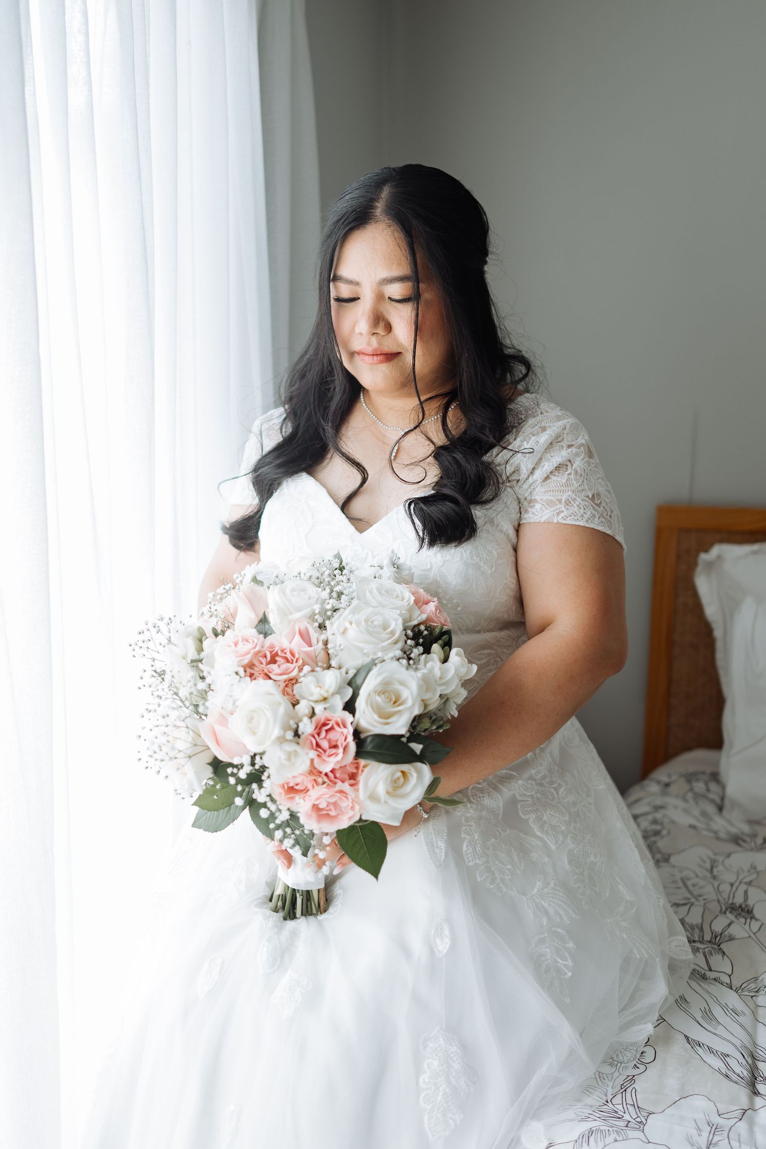 Beautiful bridal bouquet with pink and white roses against a white dress.
