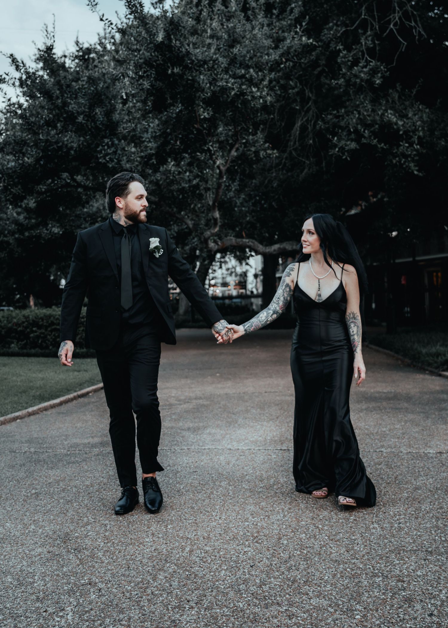 Couple in all black outfits walk together on gravel path showing progressive movement across five connected frames.