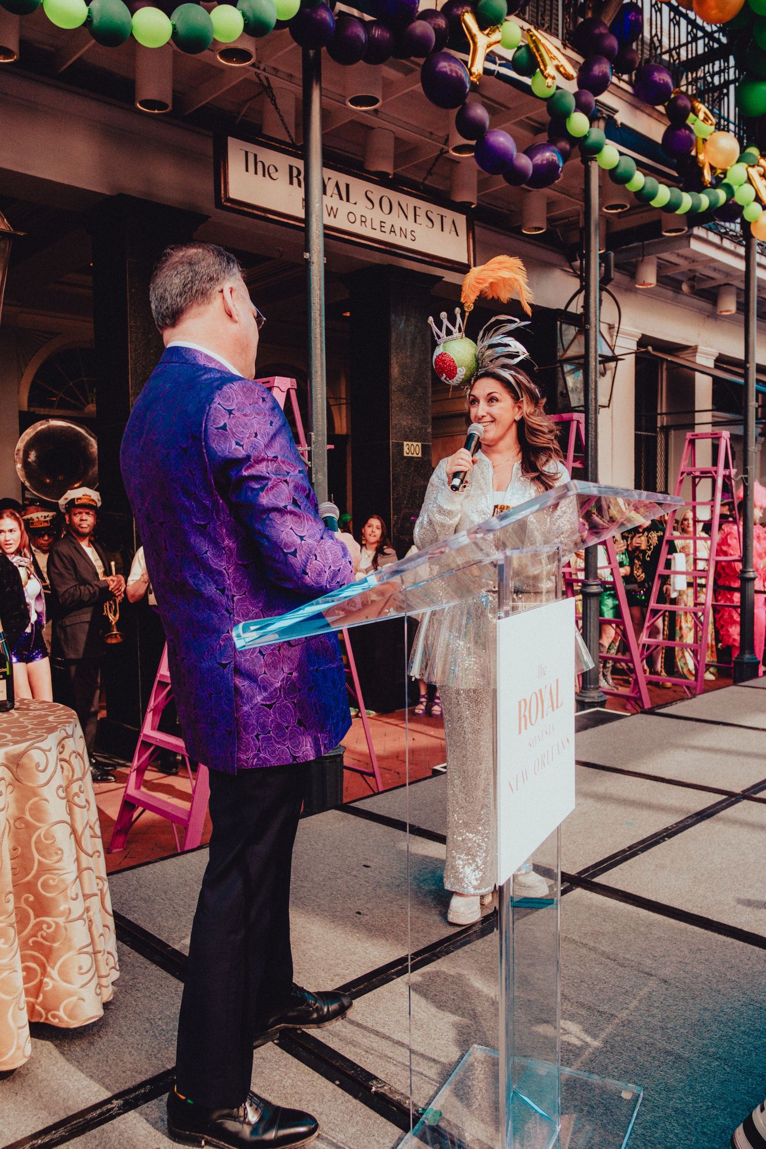 Festive ceremony taking place outside Royal Sonesta hotel with colorful balloon decorations.