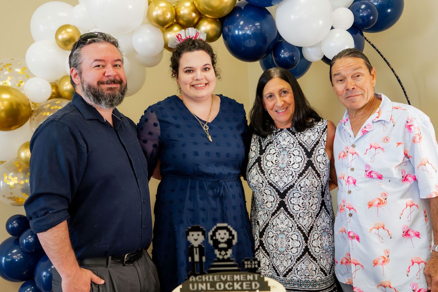 Celebratory event setup with navy and gold balloon arch decorations.