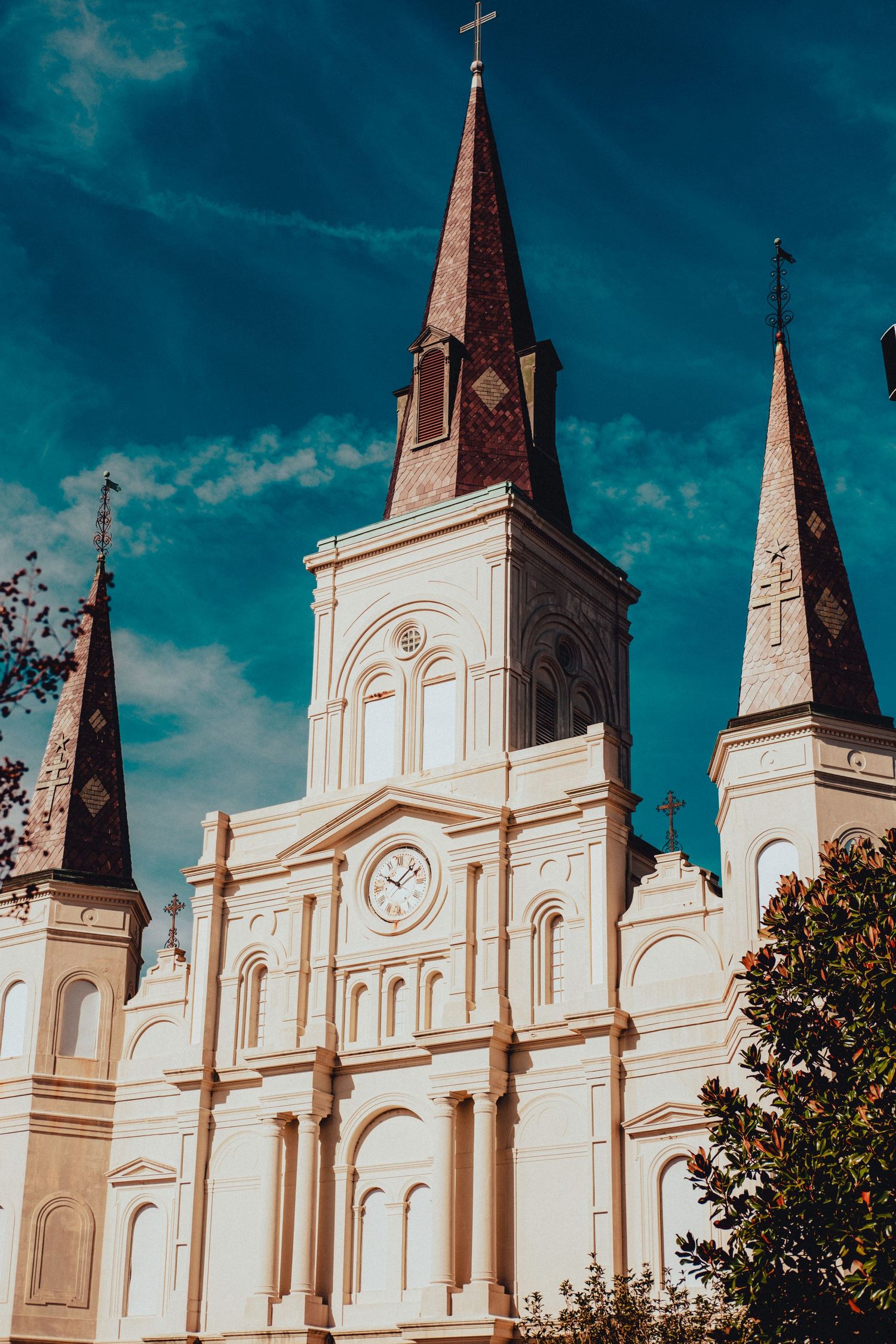 St. Louis Cathedral facade with three spires against vibrant turquoise sky in New Orleans.