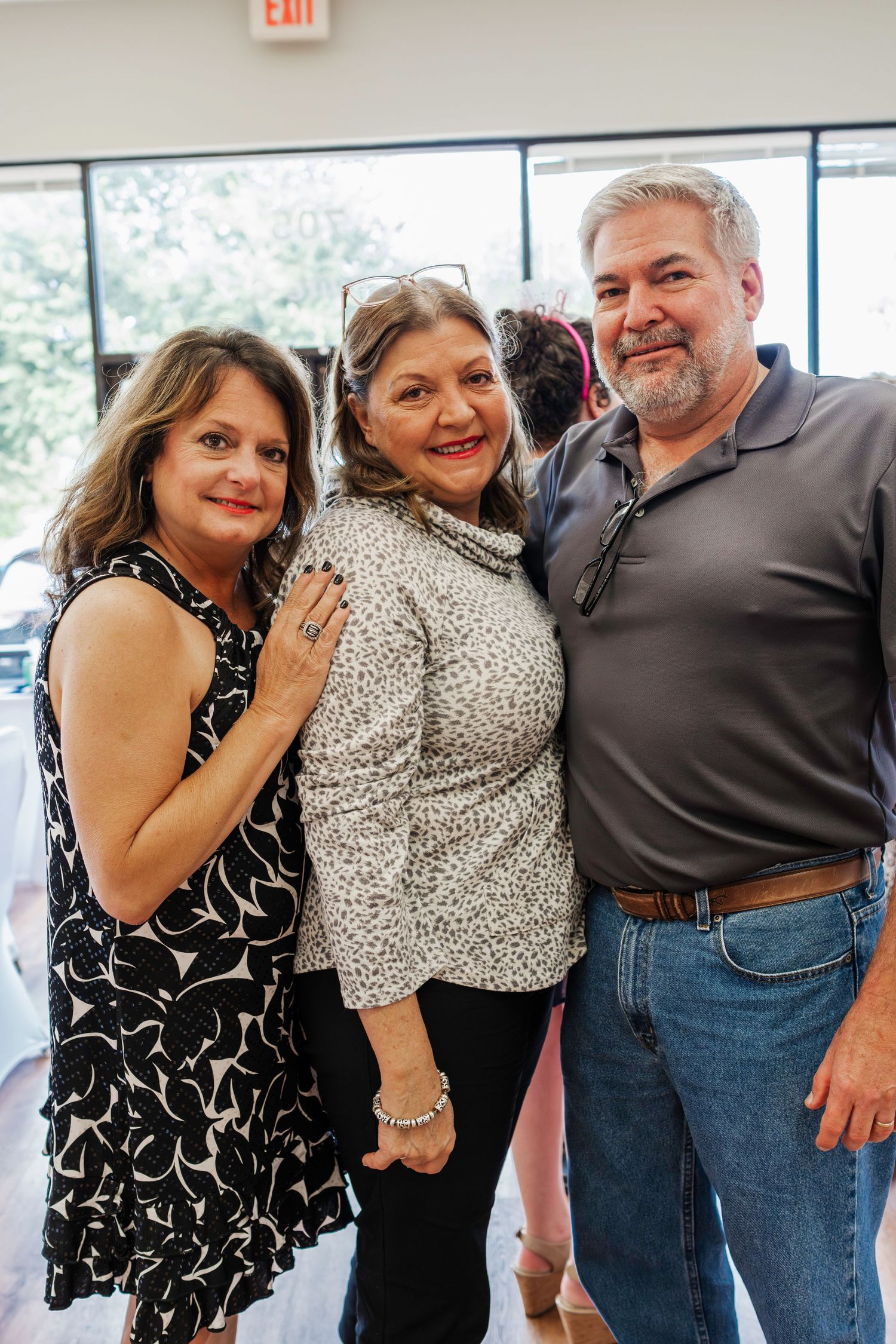 A celebratory gathering with people smiling together at an indoor event.
