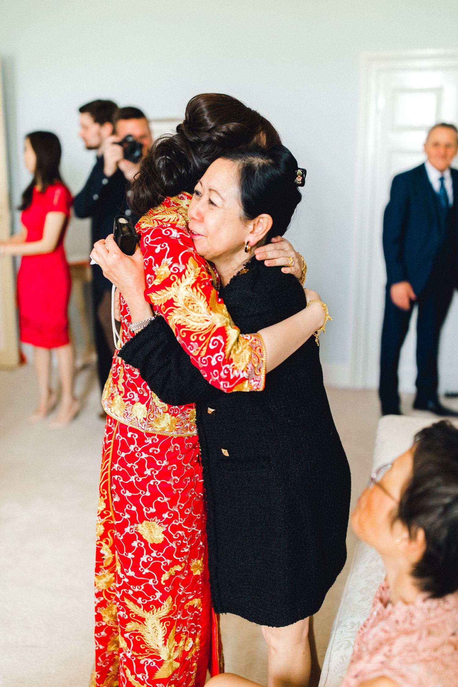 Emotional hug between bridge and family during a tea ceremony  – Gosfield Hall Essex