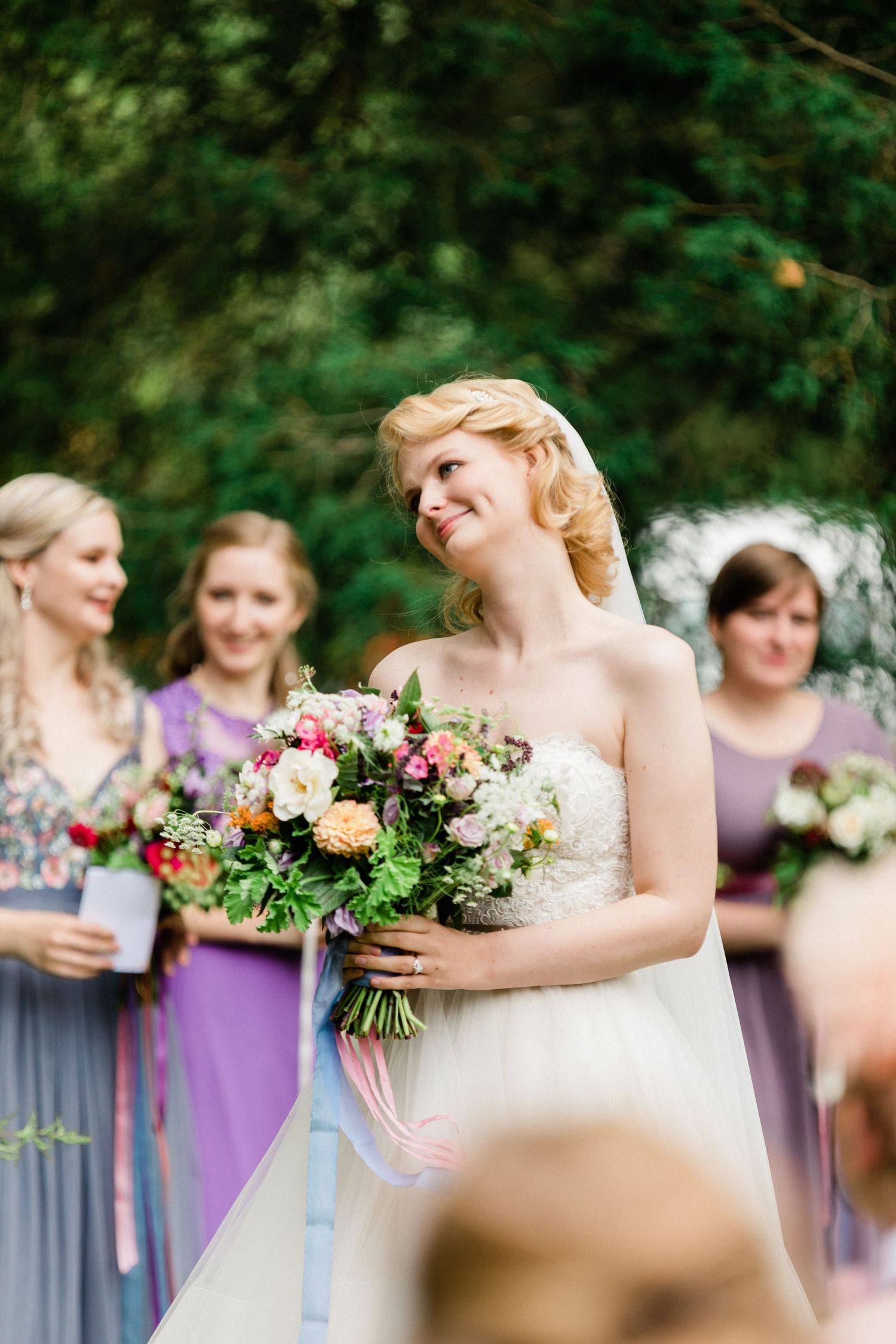 Candid photo of bride’s joyful smile as she listens to groom’s vows in France