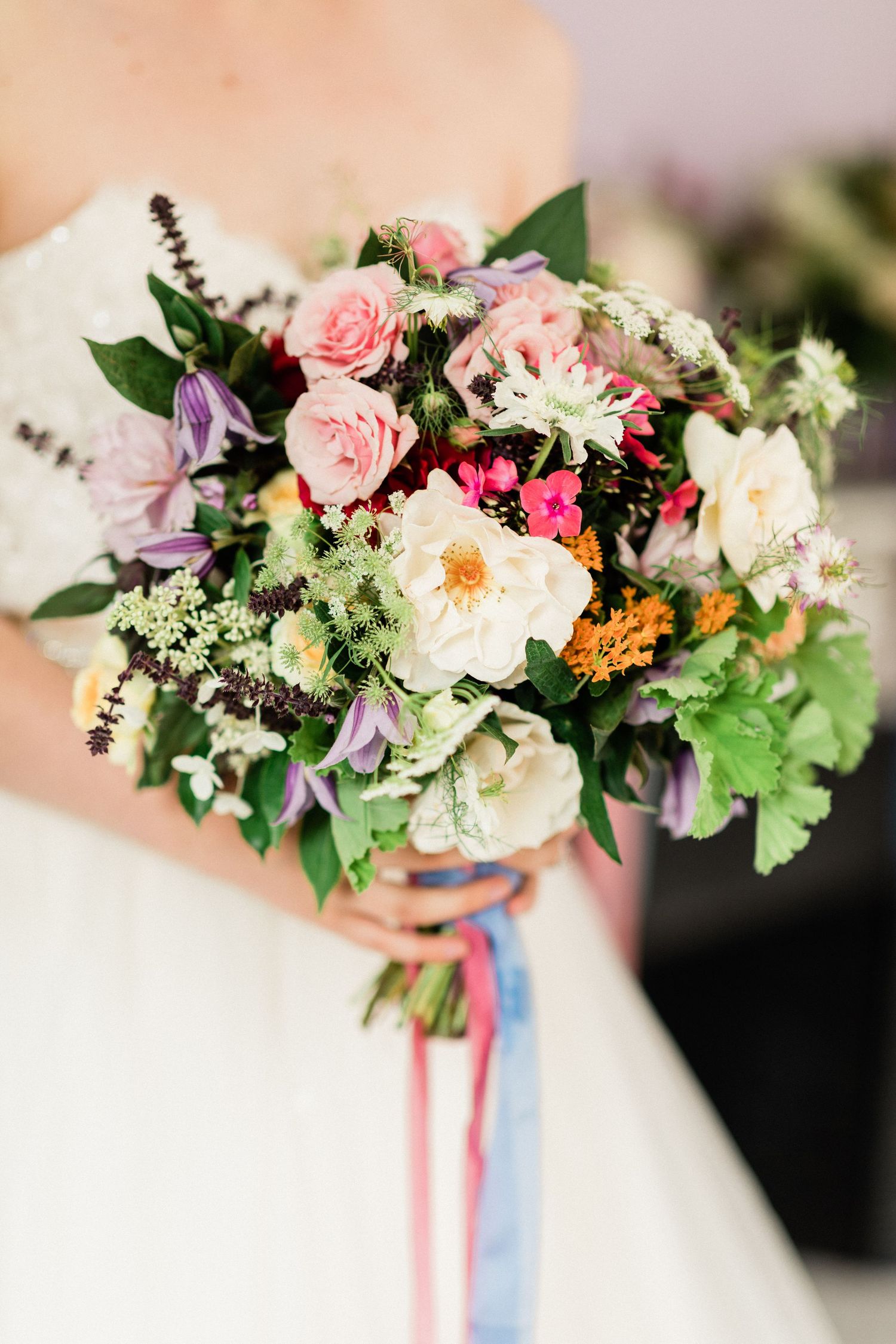 Close-up of bride holding romantic bouquet with soft pastel flowers in French wedding