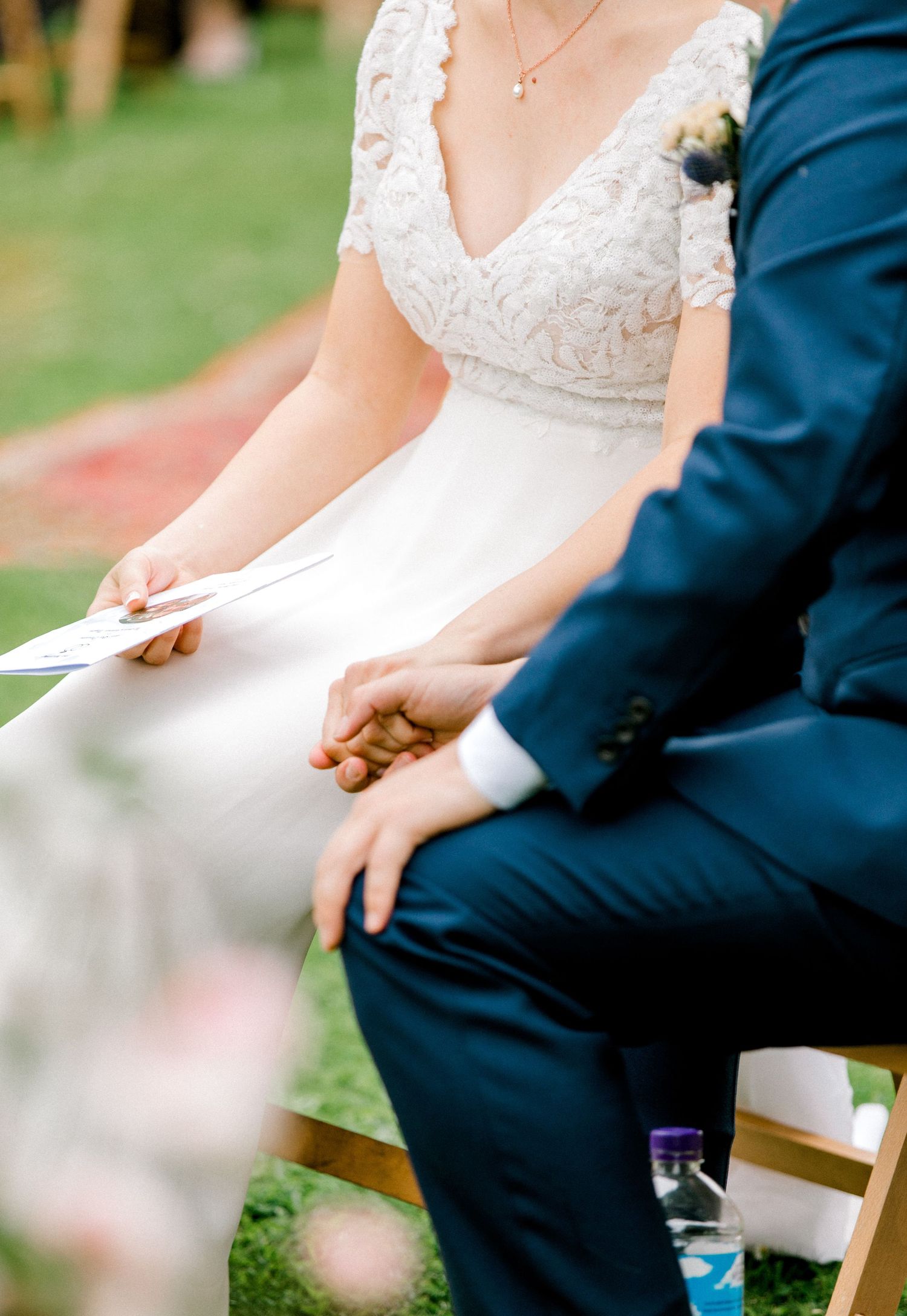 Candid moment of bride and groom holding hands in ceremony garden London wedding summer