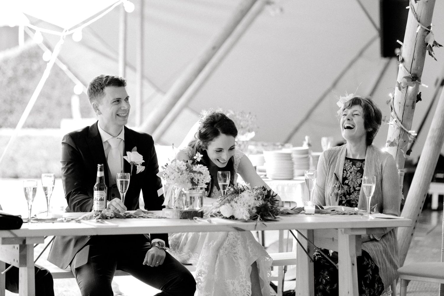 Joyful bride, groom and guest reactions captured during evening speeches in marquee reception Hoath House Kent