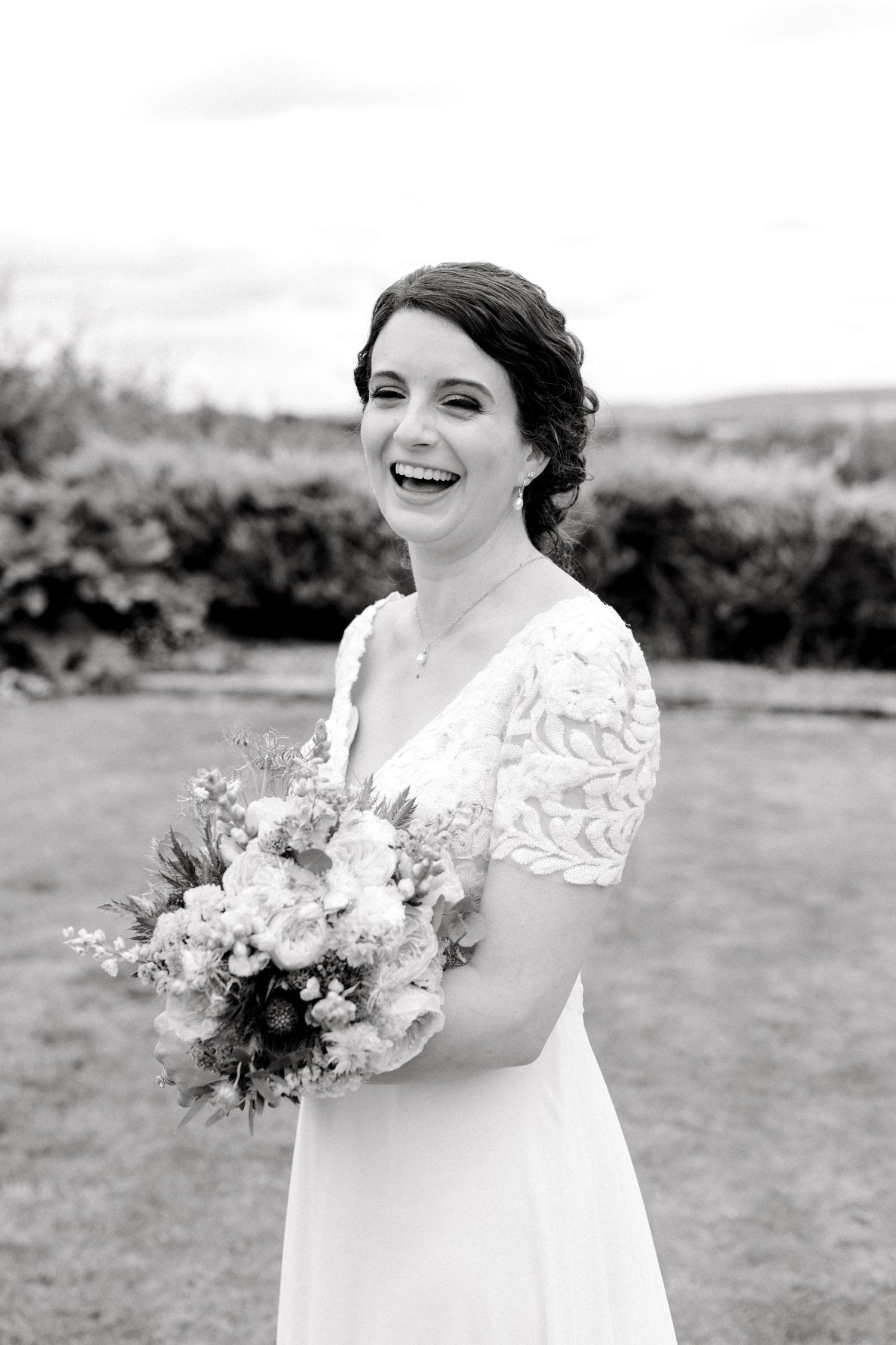 Natural light portrait of bride with veil and bouquet in hand outside in London