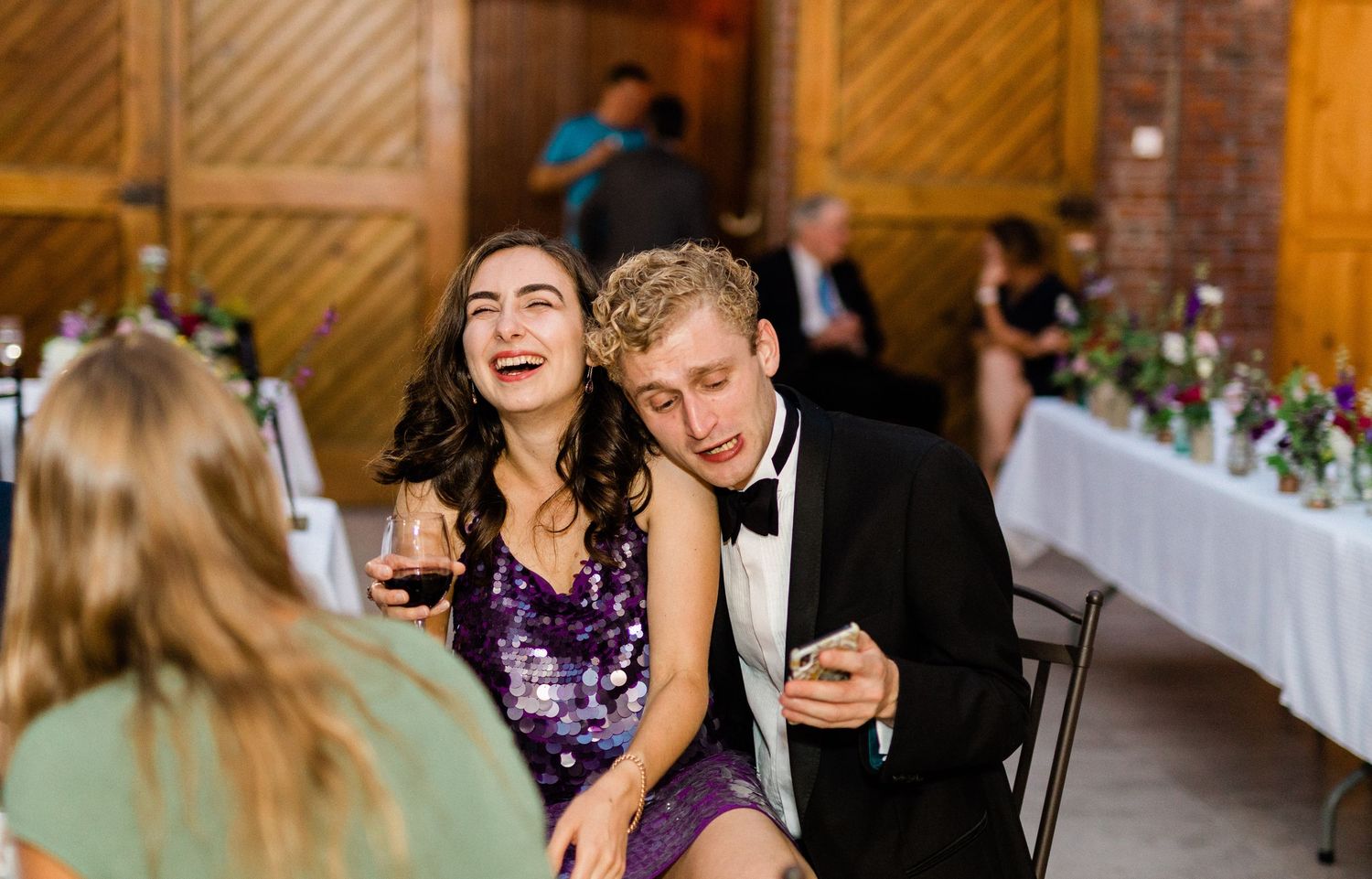 Candid photo of guests laughing at wedding reception in France in a chateau