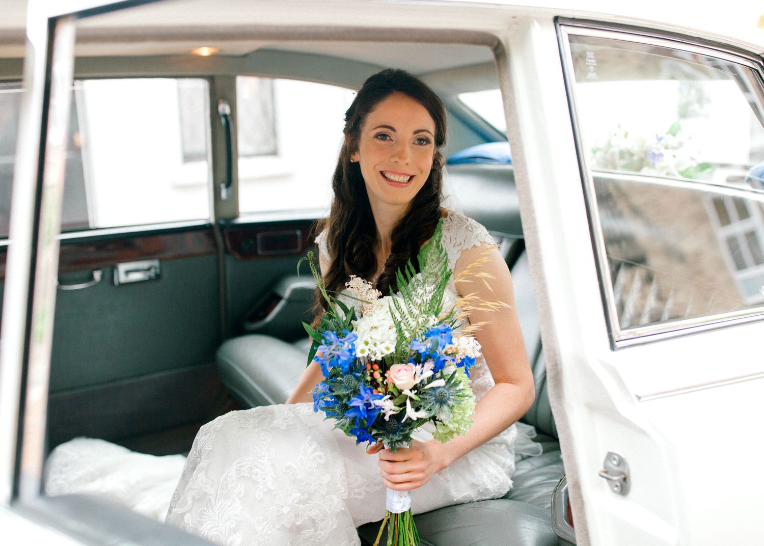 Beautiful bride sitting in wedding car moments before walking down the aisle in a church in Kent