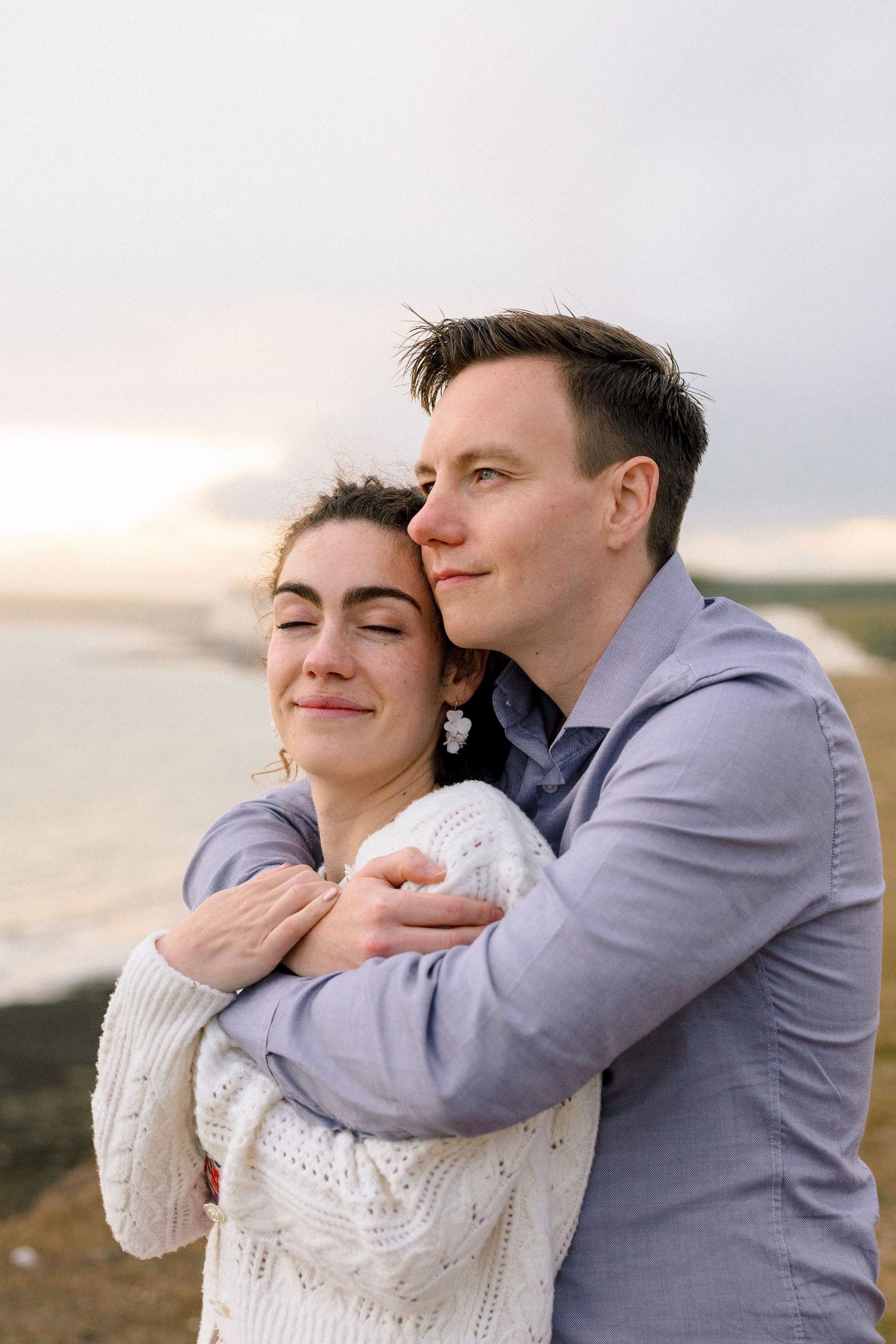 Bride-to-be and groom embracing in golden hour light during professional engagement shoot in Kent