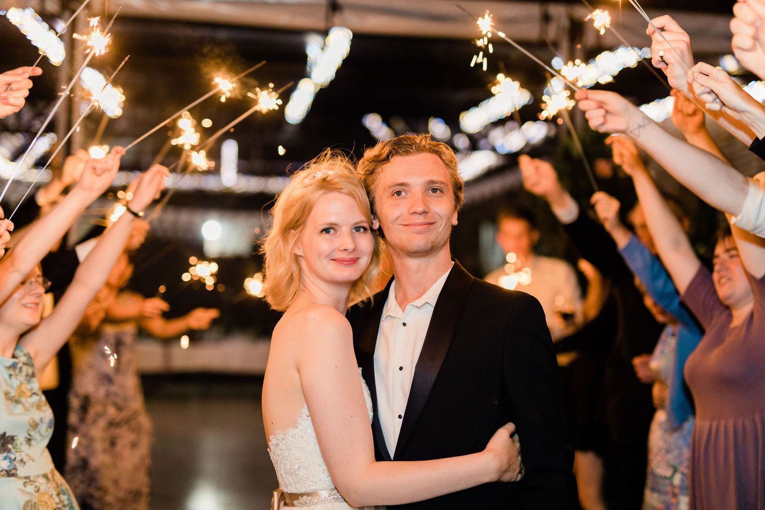 Evening sparkler exit with bride and groom surrounded by cheering guests in Hallines France