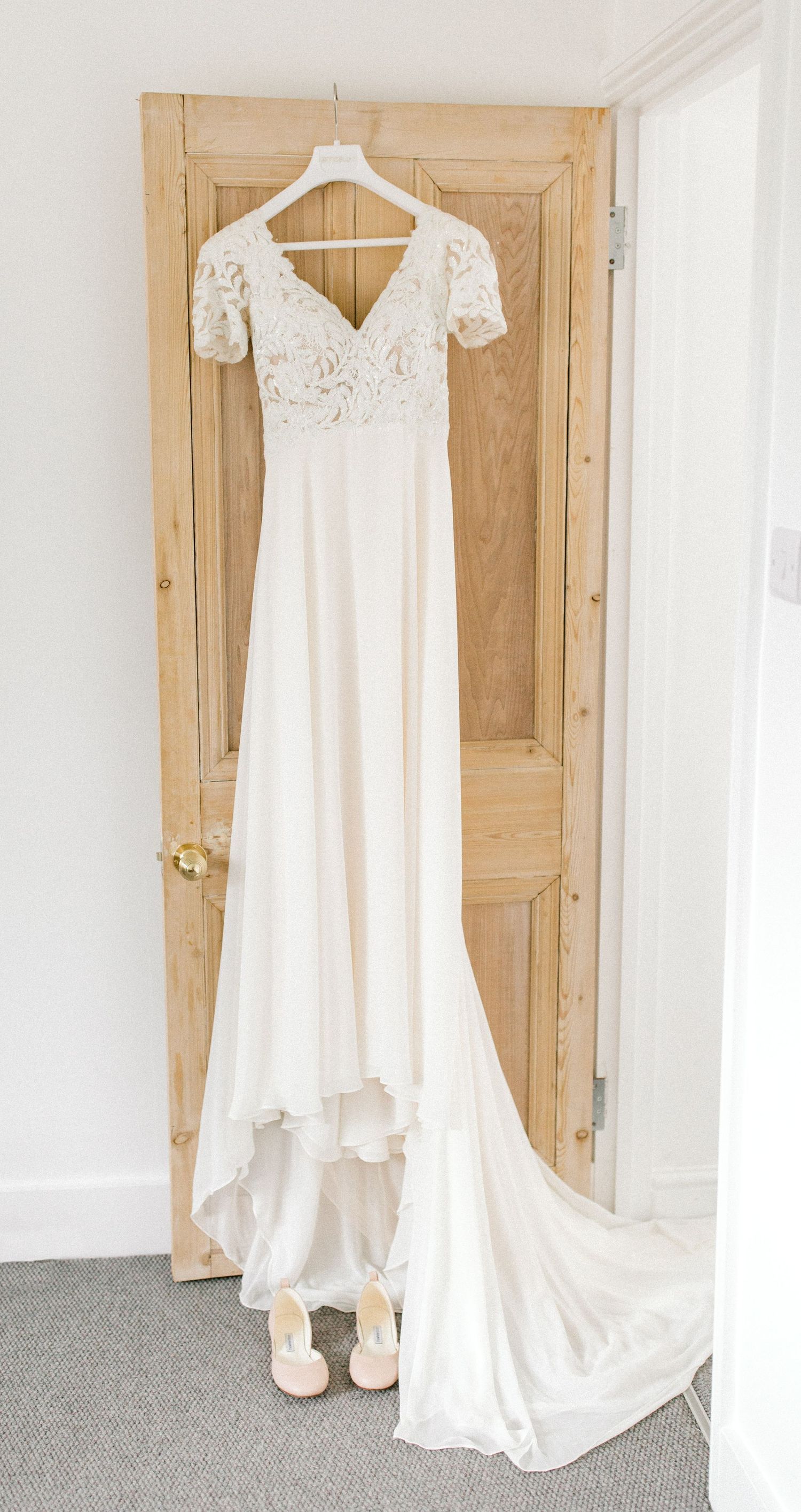 Bride’s dress displayed together beside her heels – soft, romantic wedding prep image