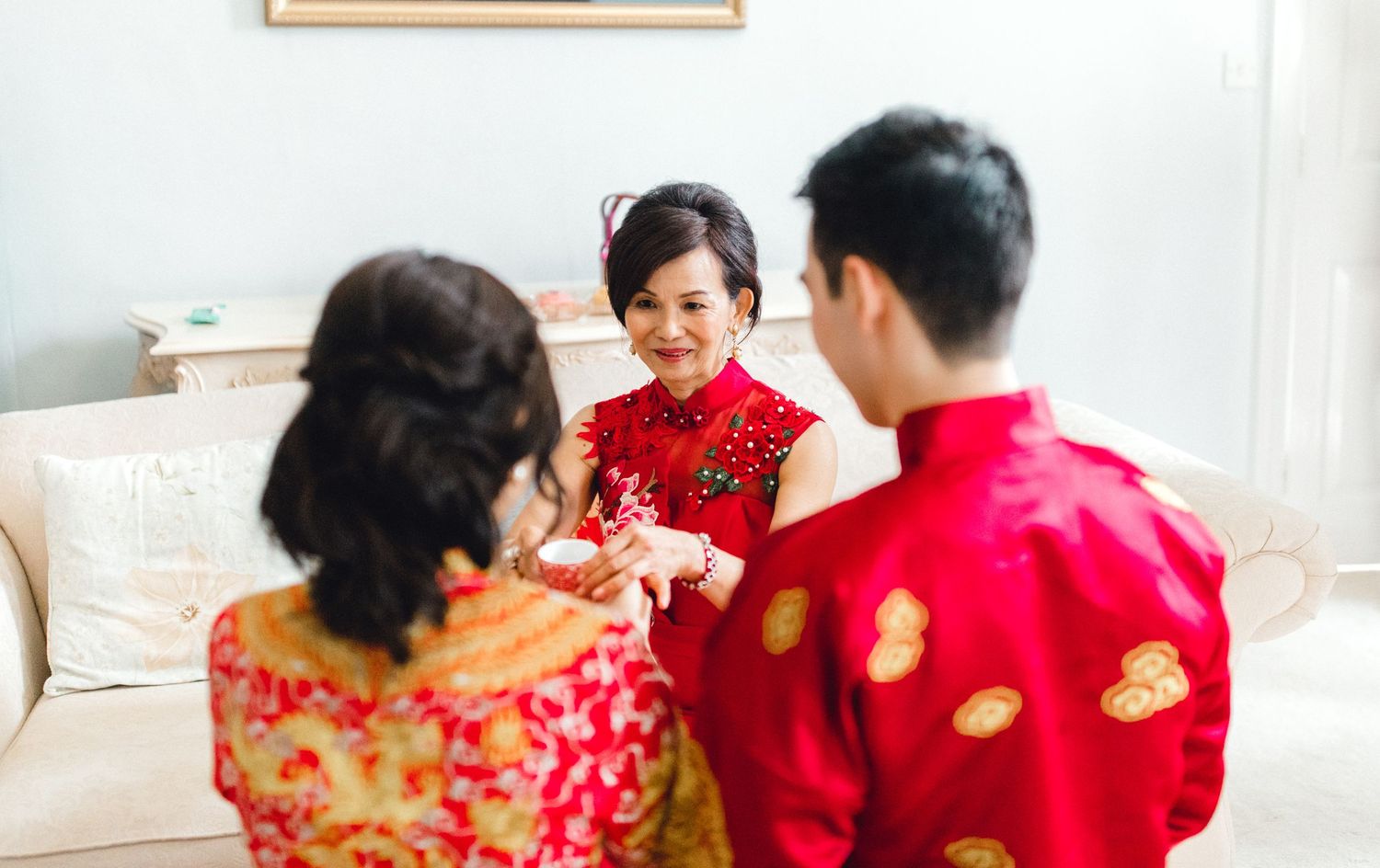 Chinese wedding photography showing couple presenting tea to mom during ceremony in Gosfield Essex