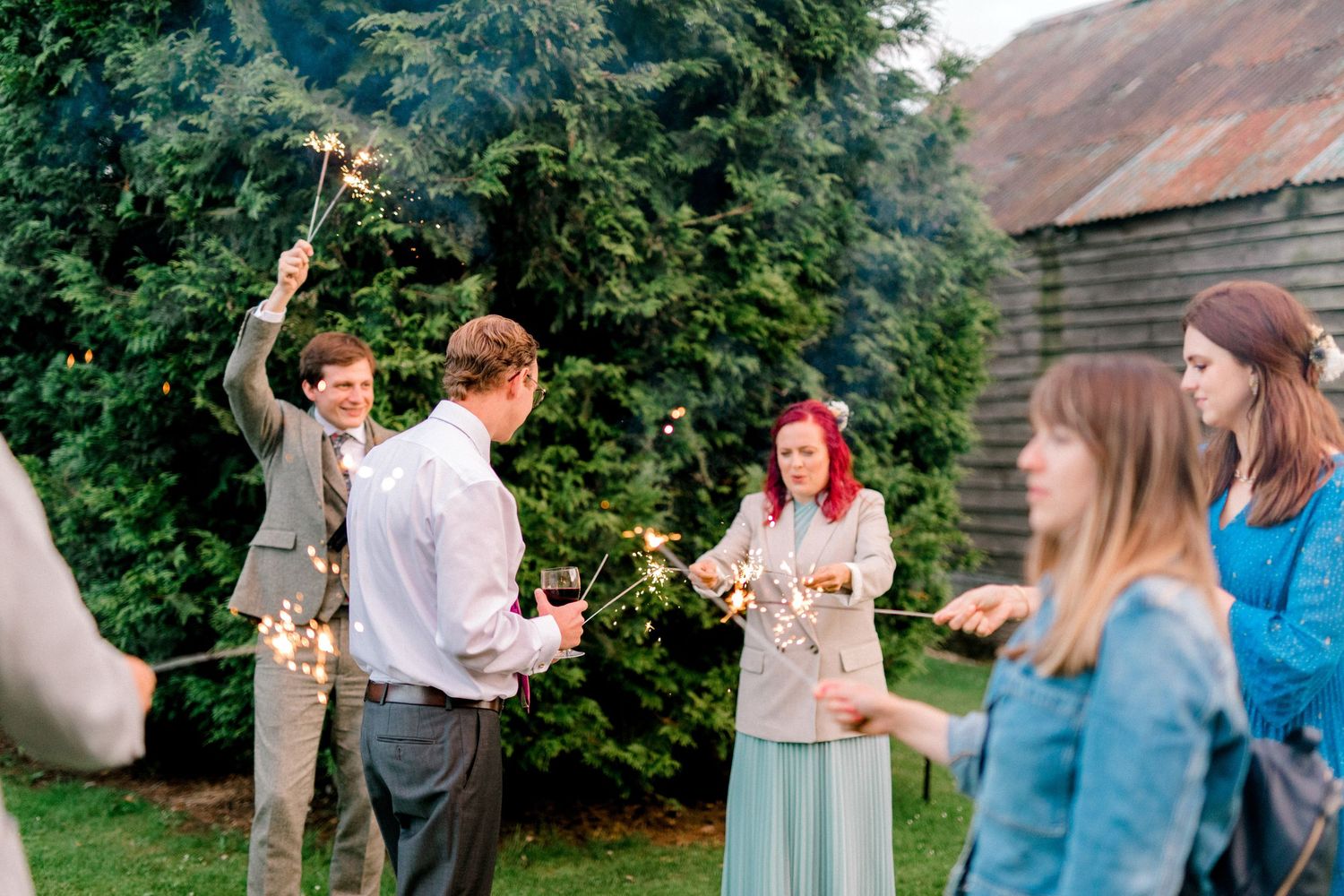 Wedding guests holding sparklers during evening celebration in London