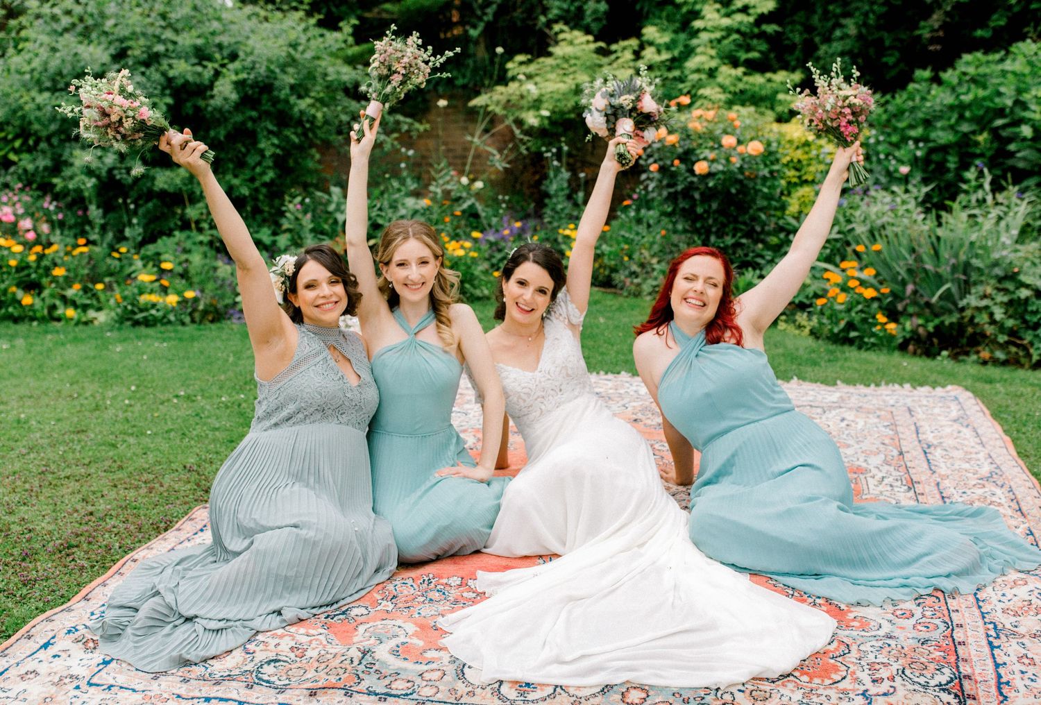 Bride with bridemaids posing for a fun group photo in childhood garden Buckinghamshire
