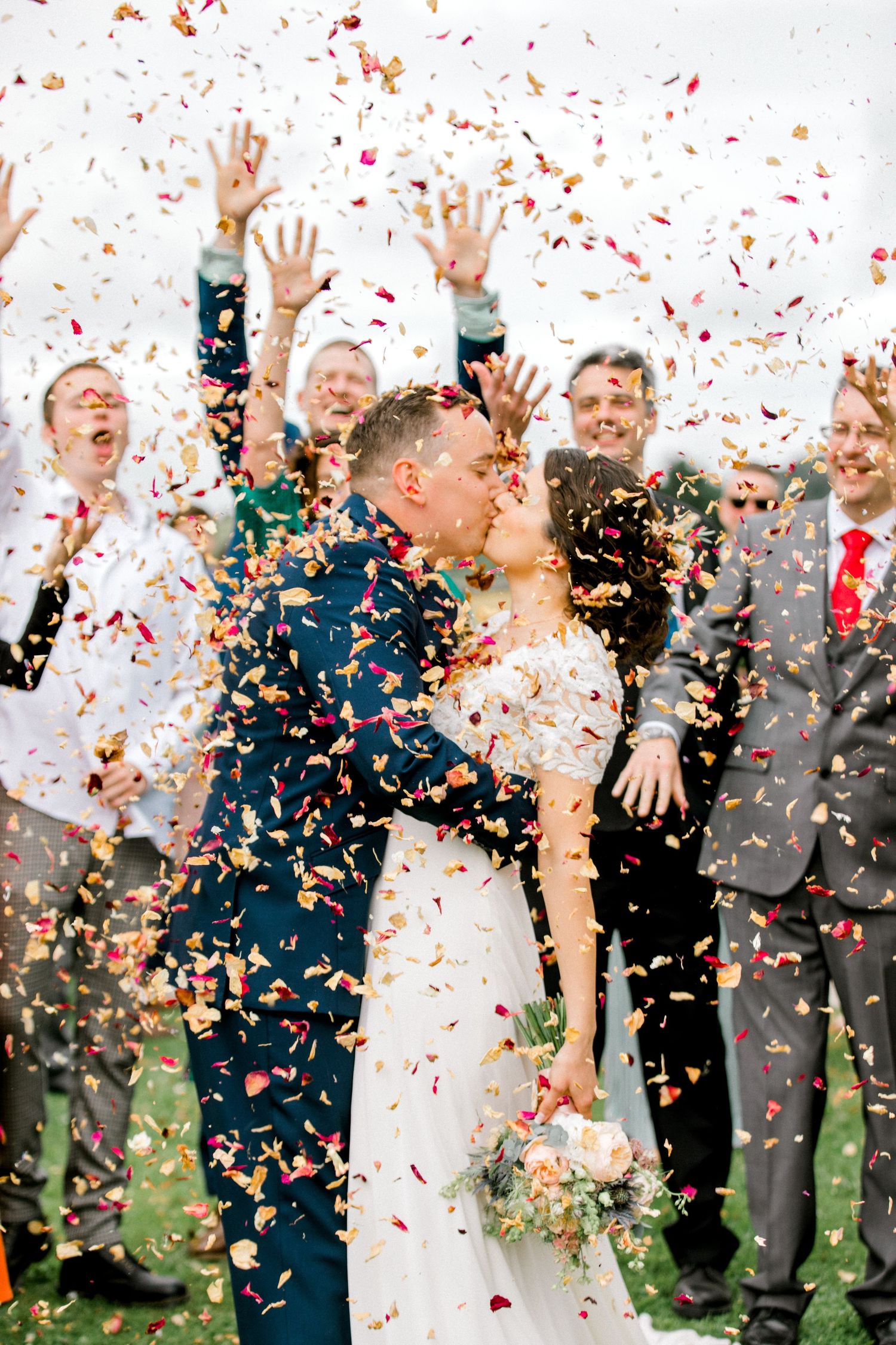Wedding photography capturing couple's kiss surrounded by falling wedding confetti in London