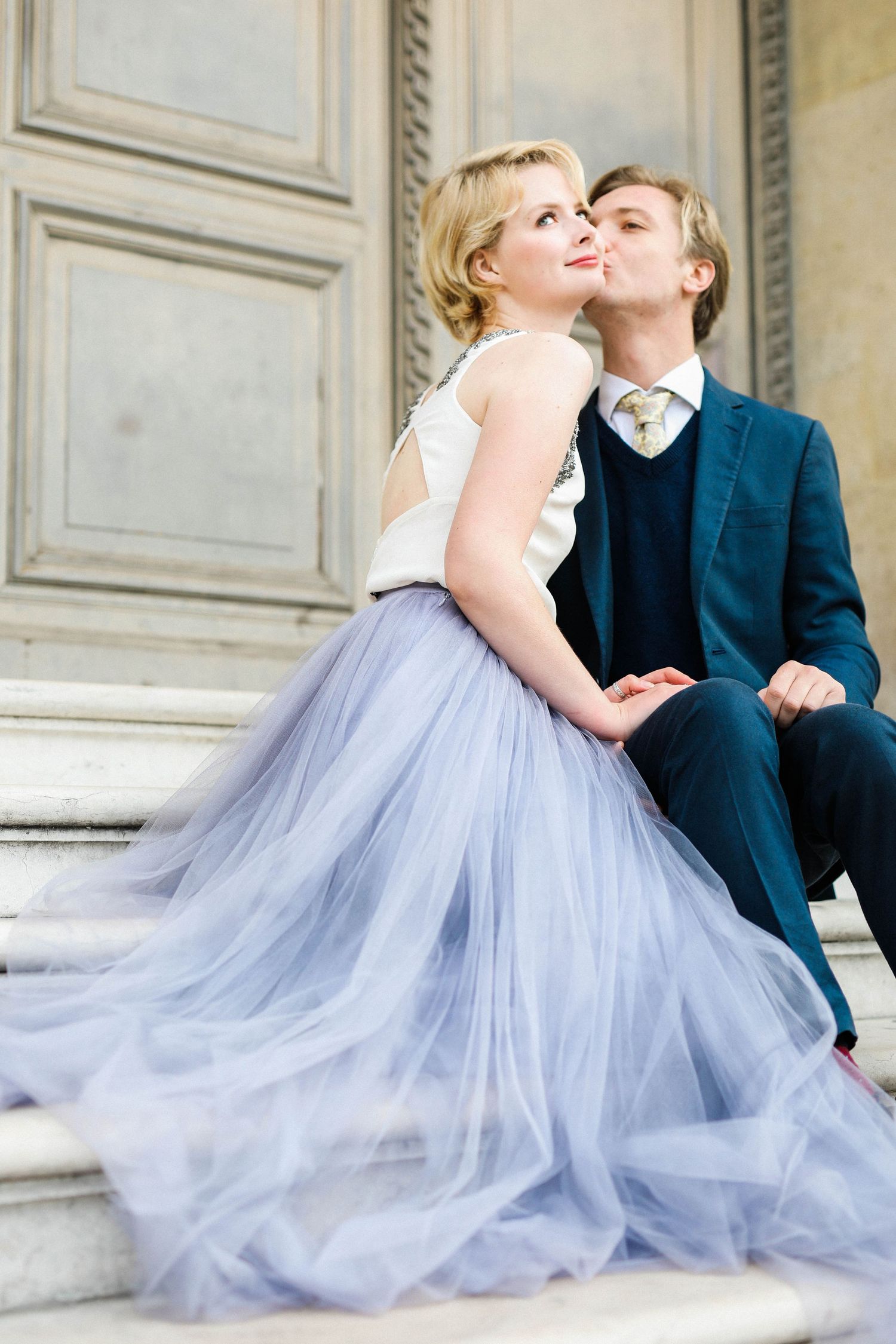 Candid engagement photo capturing bride's sweet cheek kiss during photoshoot in Paris France