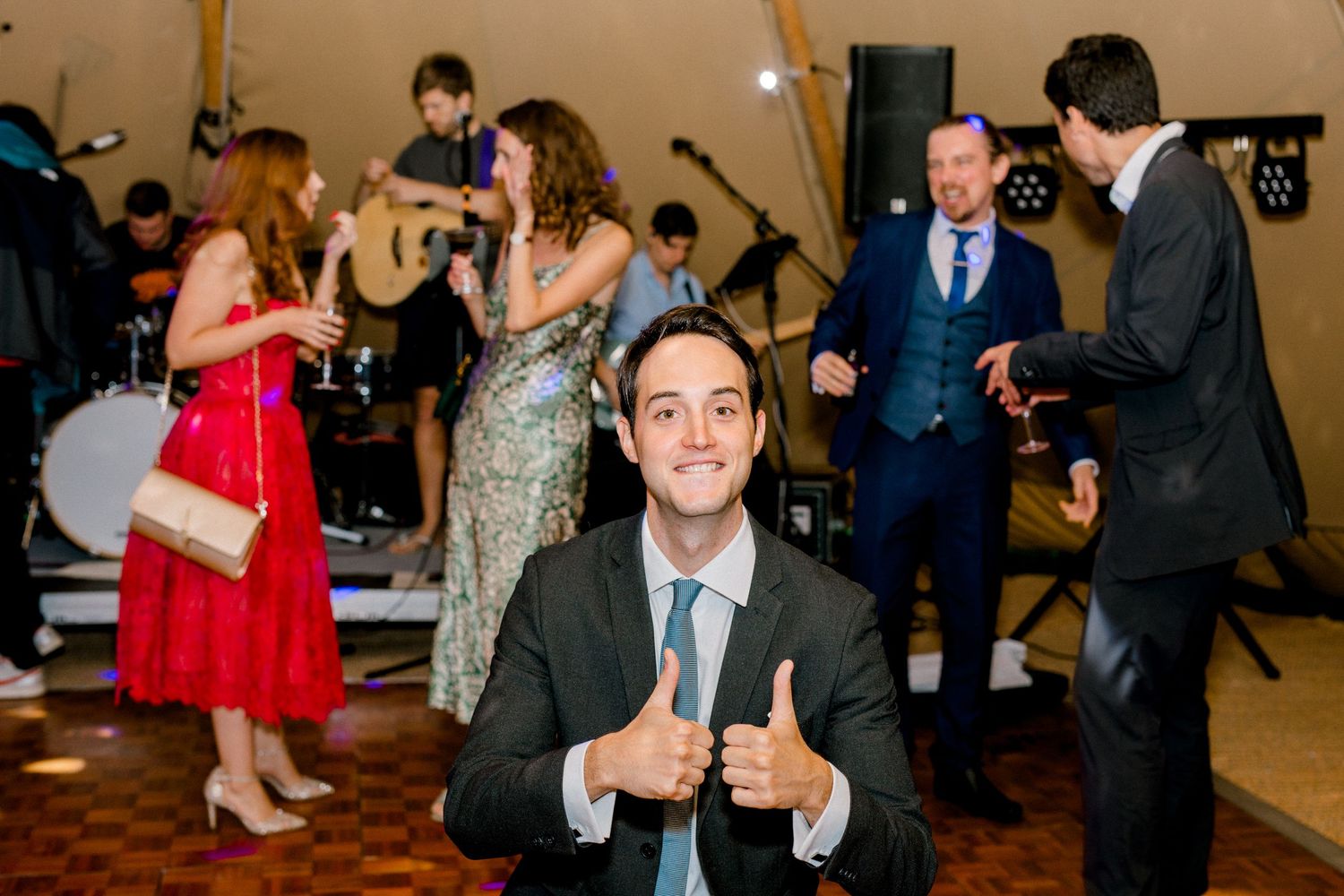 Guests dancing in front of live band - a candid wedding photograph of a reception in Hoath House, Kent
